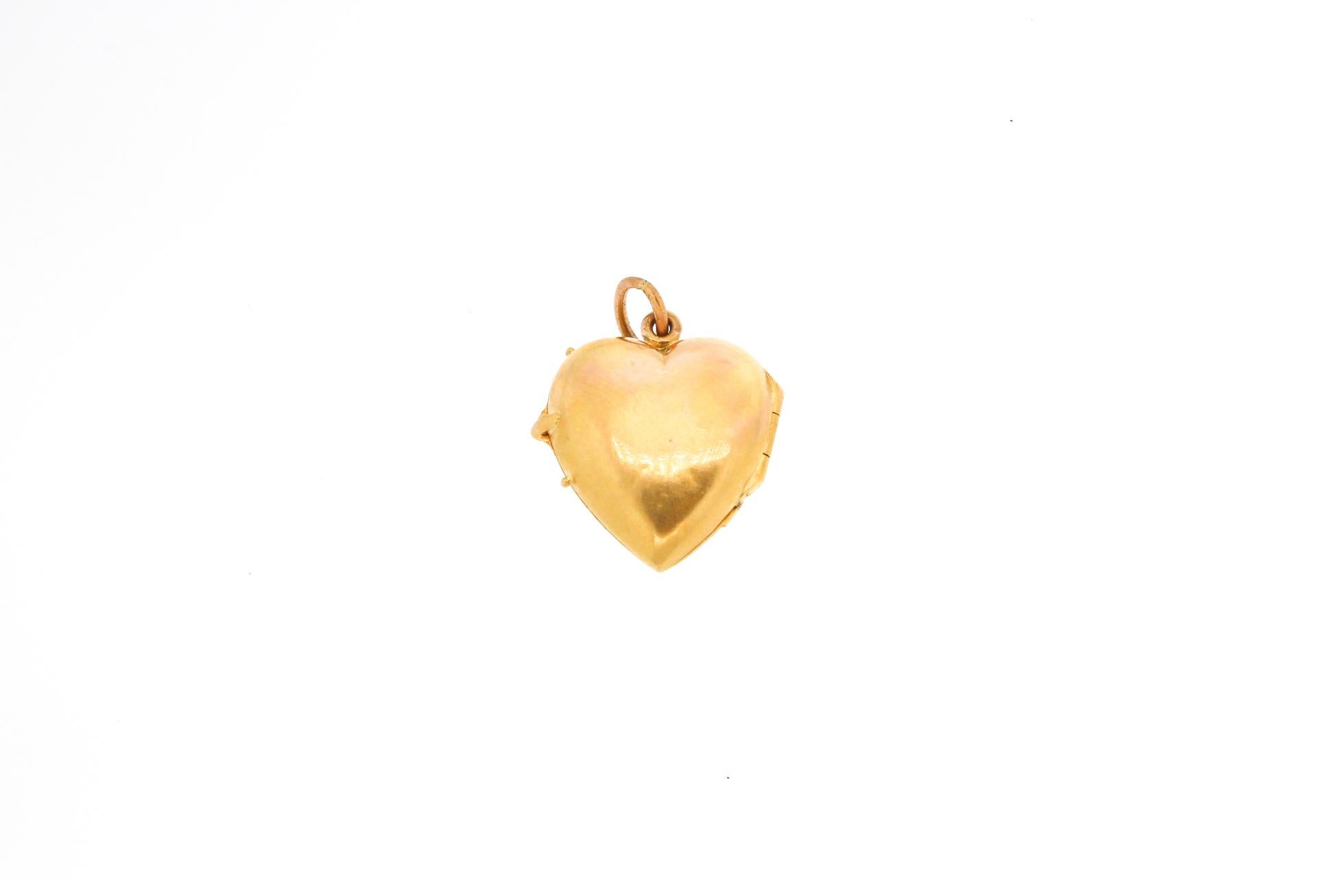 Victorian 14k gold heart shaped locket set with split pearls and demantoid garnets. The locket opens and can hold a photo, though there is no glass currently. The bloom of the gold on the front is lovely, and the gems cross the heart like a sash.