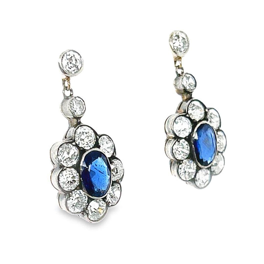 Vintage 1950's Victorian 3.44 carat diamond and sapphire cluster gold drop earrings. Featuring two oval shaped sapphires with an estimated total weight of 1.80 carats. Accented by 20 old European cut diamonds, estimated 3.44 carats, G-H color, SI