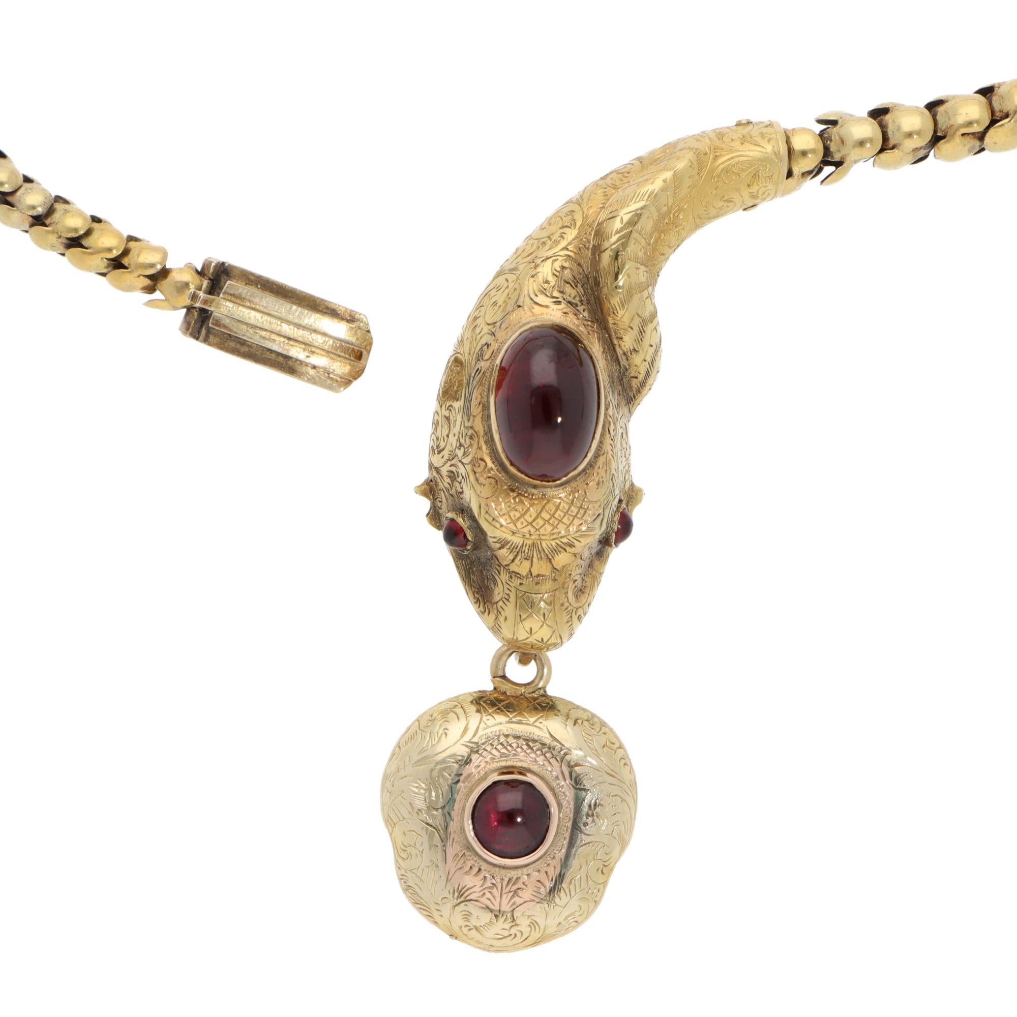 A stunning vintage Victorian garnet snake necklace set in yellow gold.

The necklace features a snake motif that is beautifully handcrafted in yellow gold with hand-engraved detailing all around. Its head is set with one large oval cabochon garnet,