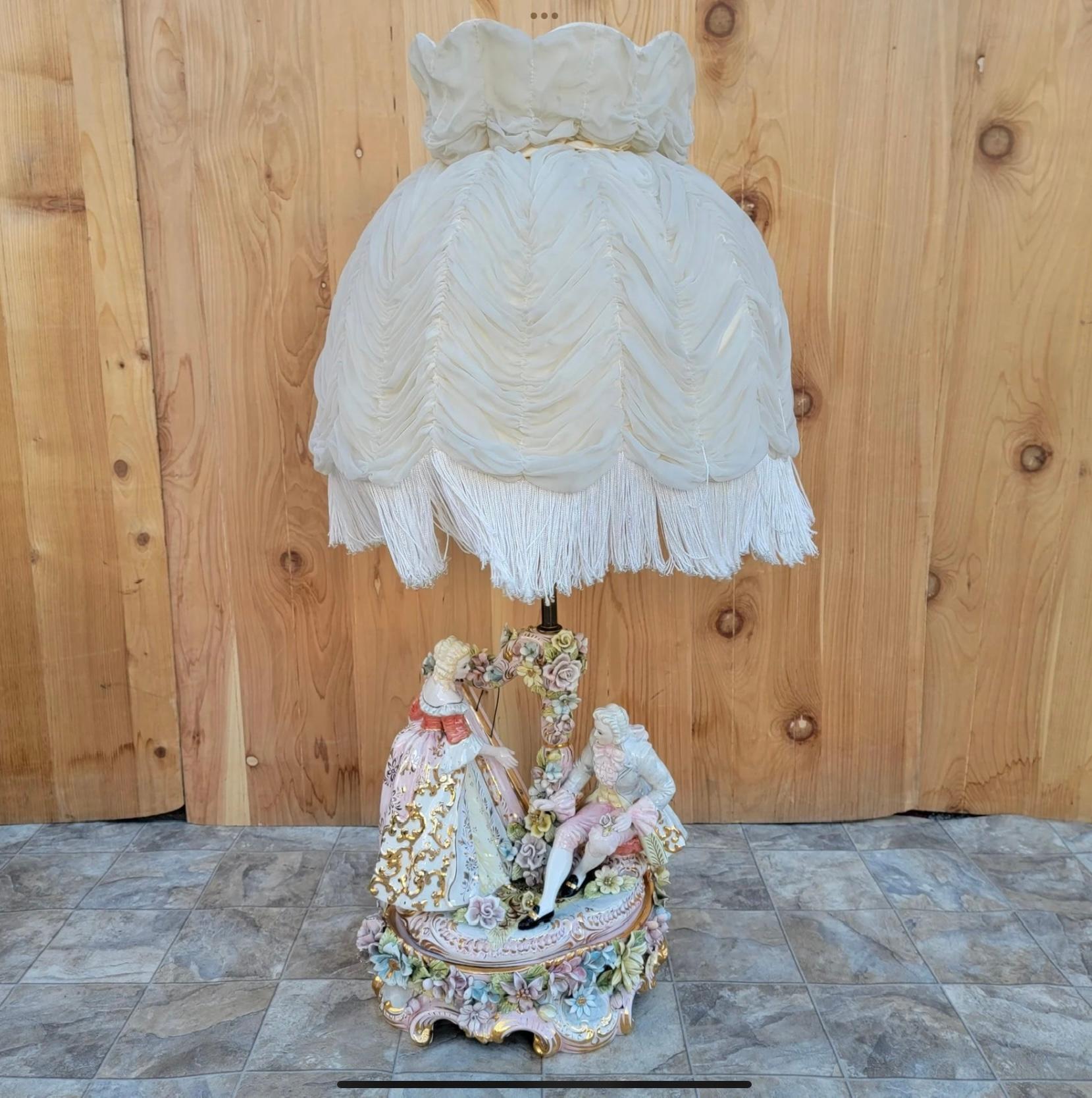 Vintage Victorian Italian Capodimonte Porcelain Table Lamp with Shade

This beautiful antique Capodimonte hand painted figurine table lamp is in great condition. It is depicting a lady playing the harp (a few strings are missing) for a gentleman. It