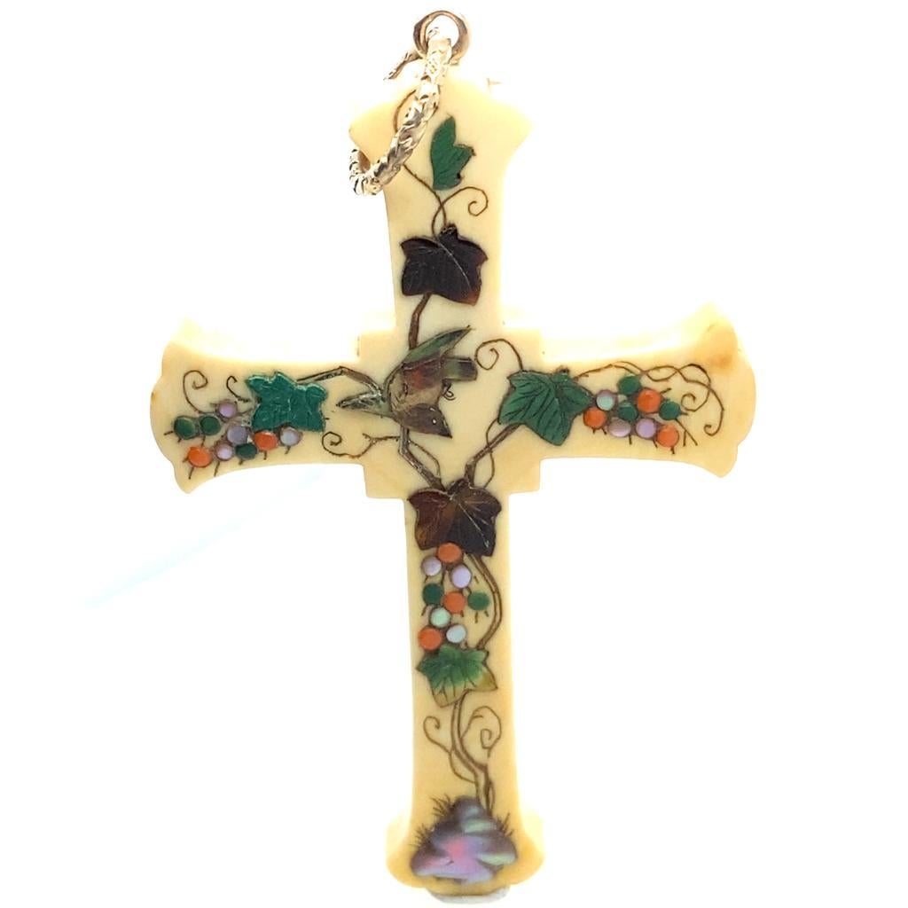 A vintage mother of pearl cross pendant, Circa 1910

This large cross pendant features intricate and realistic insects to one side worked in mother of pearl and lacquer, the reverse has an ornate flora and fauna design all set into cream coloured
