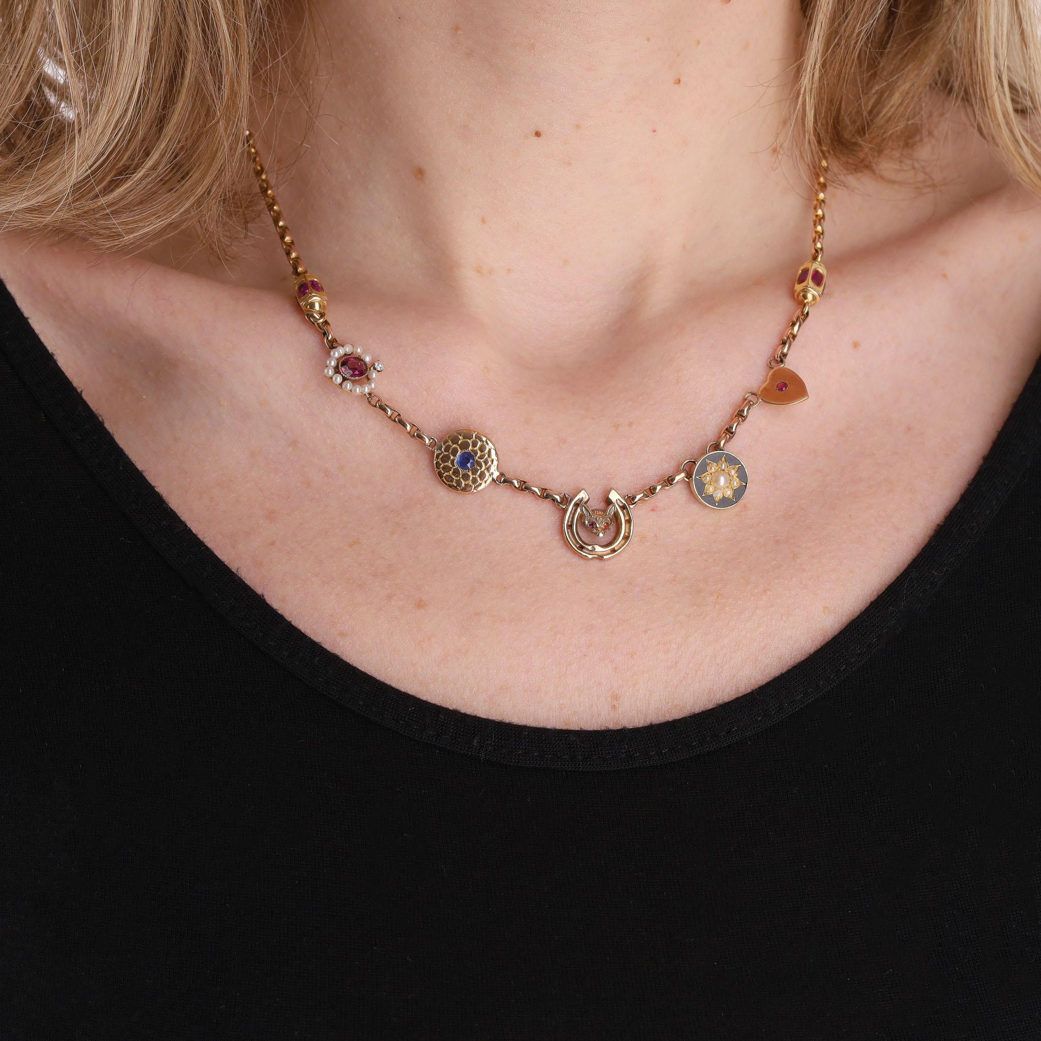 Victorian Charm Necklace 15ct Gold With Rubies, Sapphires & Pearls

Fixed multiple charms sat on a hoop link necklace.

Charms having old hallmarks in a mix of 15ct,  9ct gold and luxury gemstones such as a fox with ruby eyes in a horse shoe with