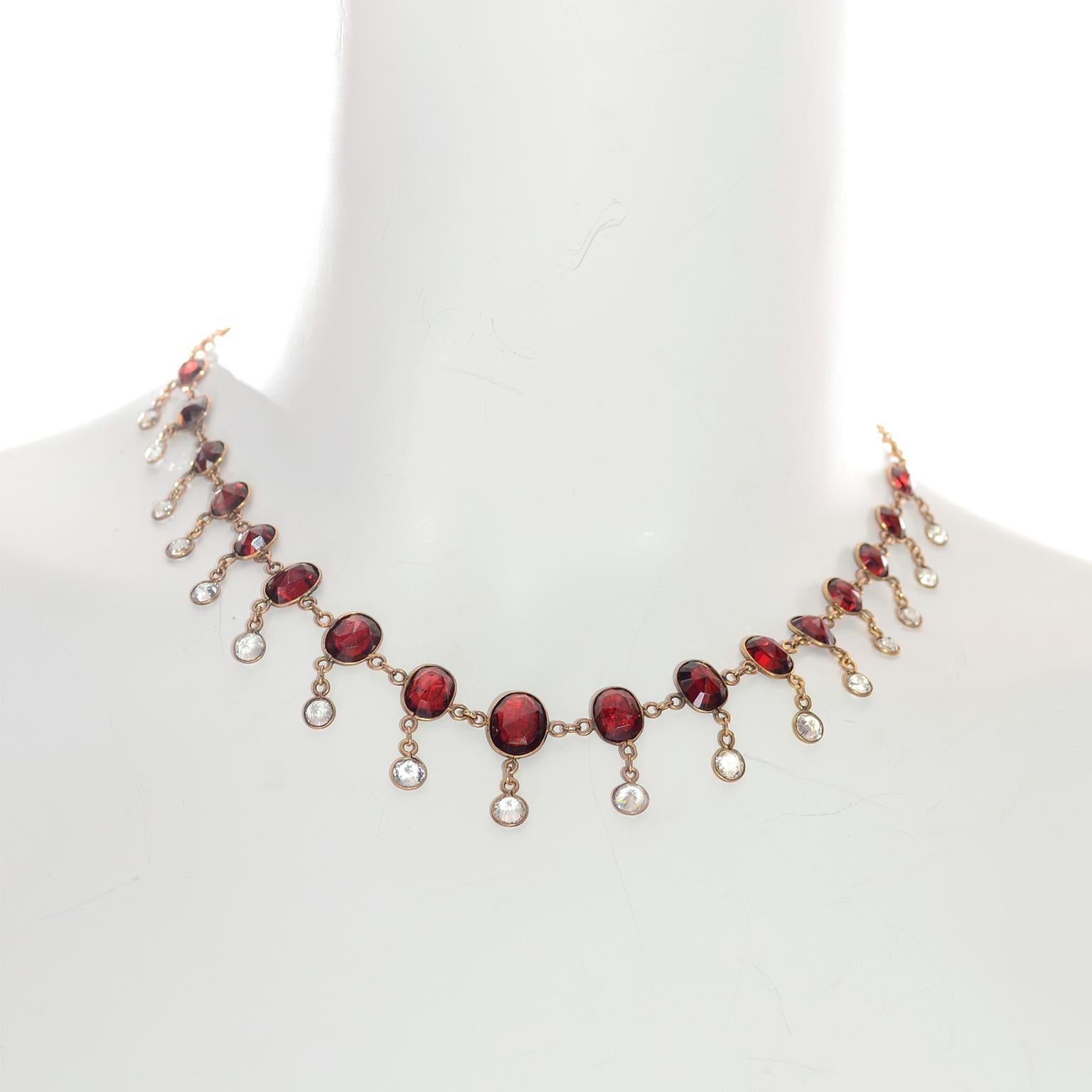 This stunning Victorian  necklace is fringe style with graduated size oval red faceted garnets and clear round faceted crystal drops set in 9k rose gold. Unmarked but tested gold. 

Garnets range in size from 5x7mm to 9x11mm.
The necklace is 16