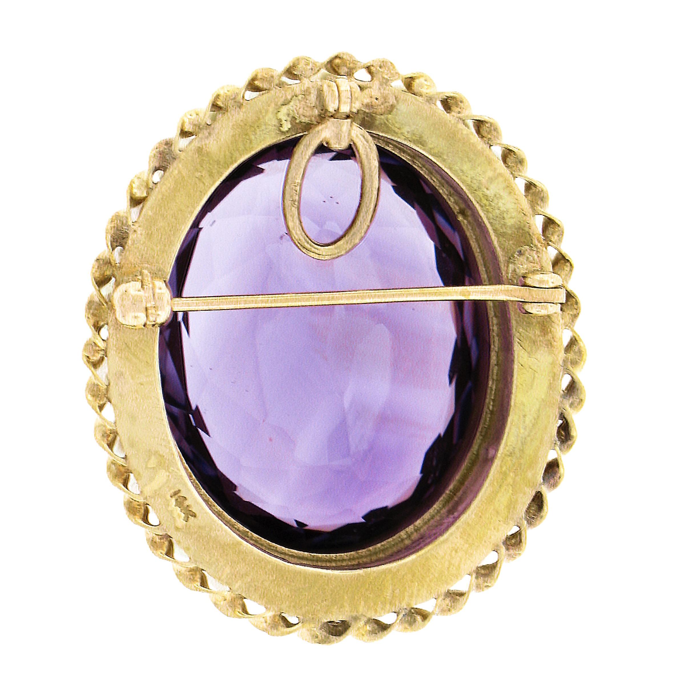 Here we have an absolutely beautiful and bold vintage brooch or pendant crafted from solid 14k yellow gold featuring a detailed Victorian Revival style design with a large, oval cut, natural amethyst stone neatly bezel set at the center of a