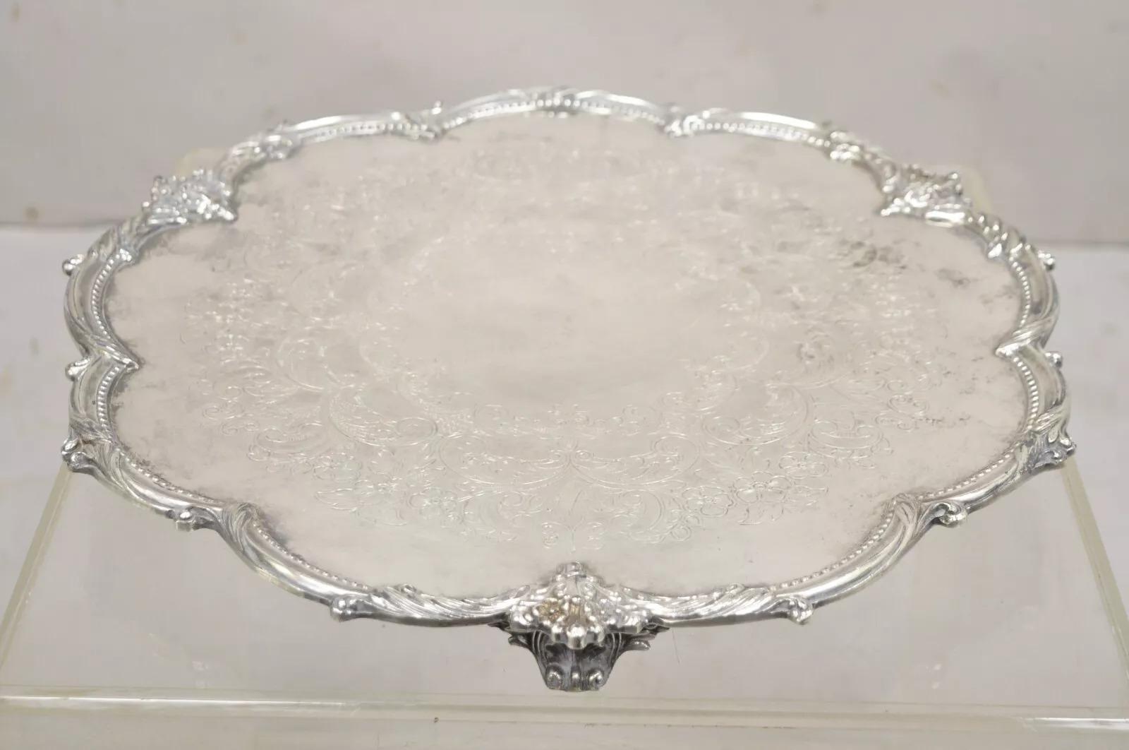 Vintage Victorian Silver Plated Round Scalloped Edge Servierplatte Tablett. Konkave Mitte, 3 verzierte Füße, florales Rankenwerk, geätzte Mitte, Originalpunze auf der Unterseite. Circa Mitte des 20. Jahrhunderts. Abmessungen: 1,5