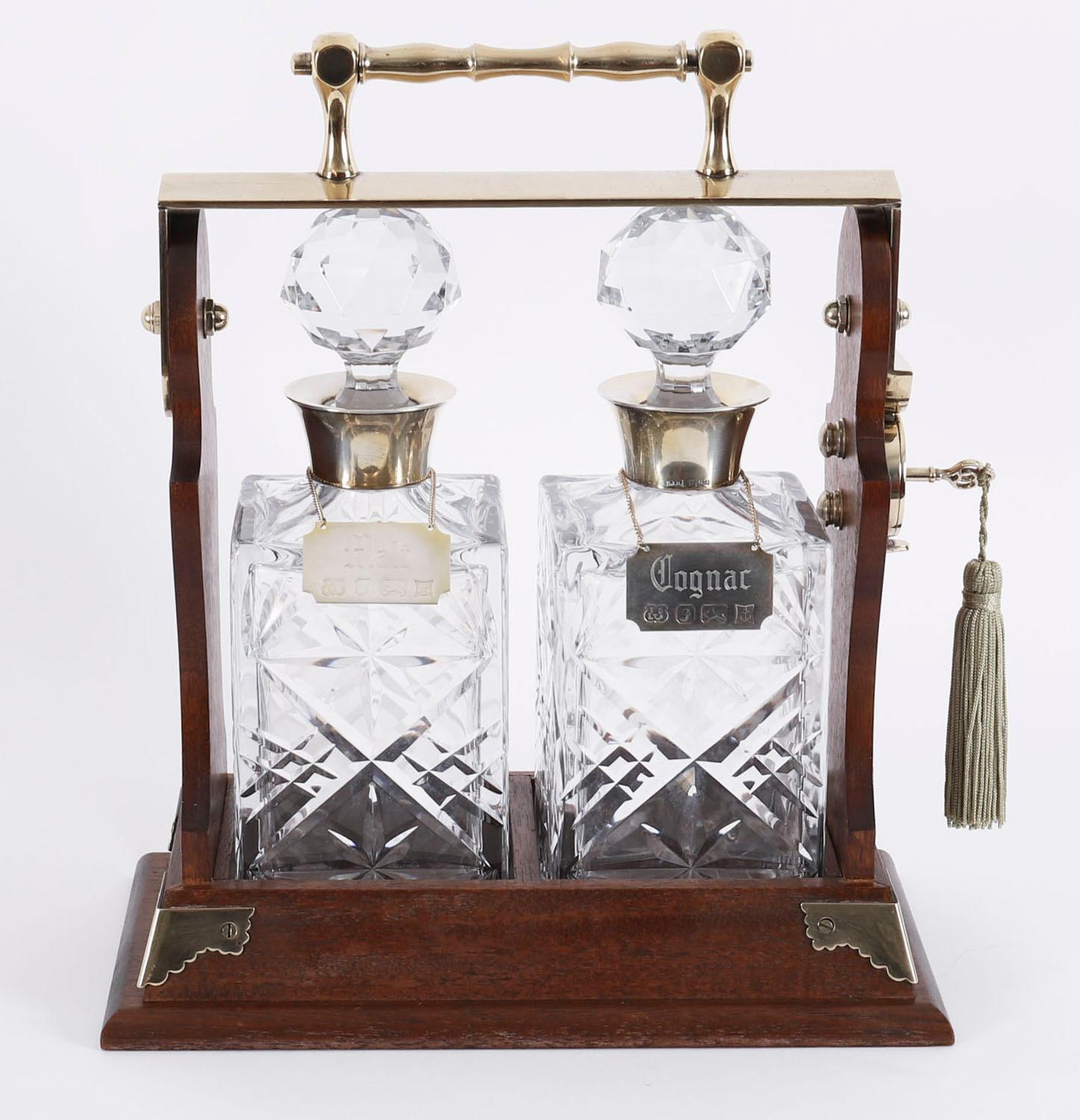 A beautiful Victorian silver plate mounted two bottle tantalus, the sterling silver mounted decanters bearing hallmarks S J Rose & Son , Birmingham 1983.

The polished walnut case has a fine grain with superb caramel hues and features a pair of cut
