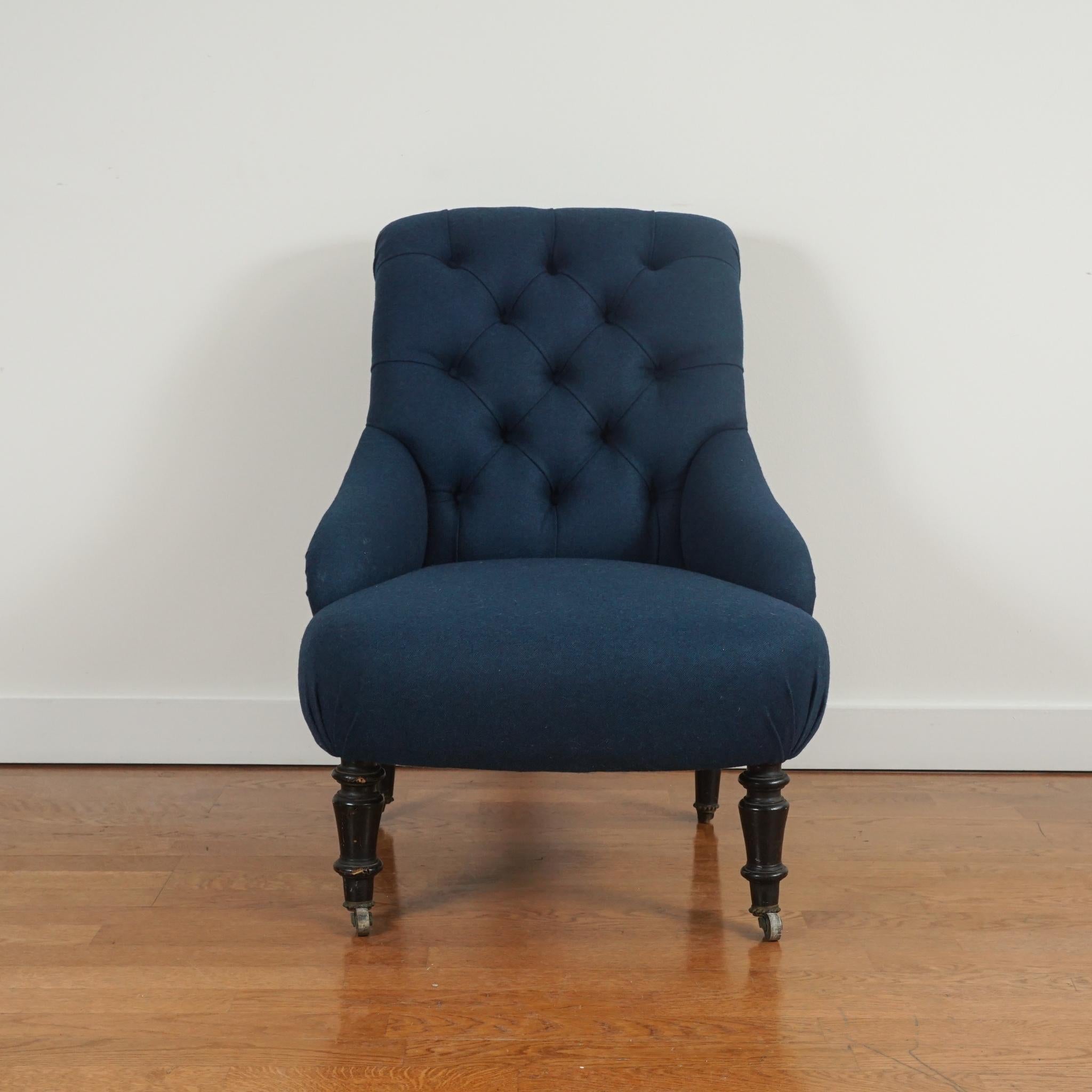Le fauteuil victorien vintage, présenté ici, a été retapissé dans un mélange de laine vénitienne Coraggio couleur paon. Le dossier touffeté et l'assise serrée sont d'origine, de même que les pieds en bois tourné, qui ont également été restaurés.