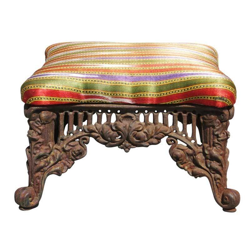 Gorgeous Victorian/Queen Anne Style cast iron foot stool with stripped multicolored fabric top.

It measures approx.14