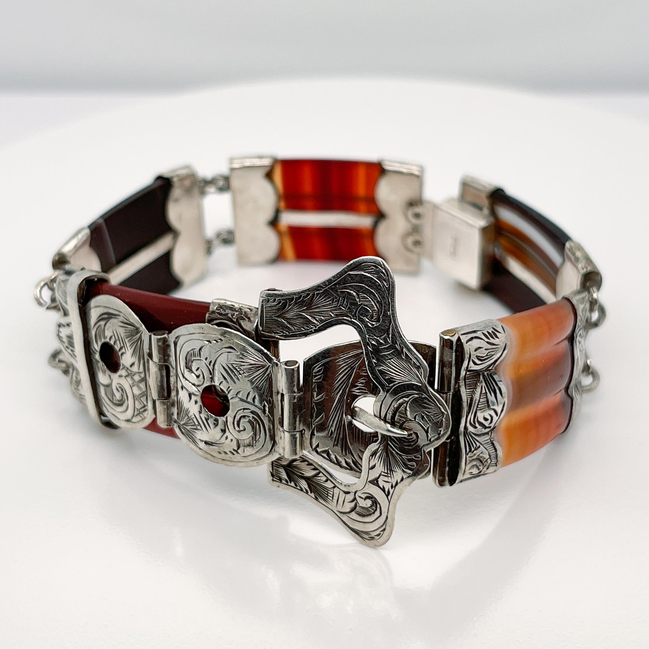 A fine vintage Scottish agate bracelet.

In the Victorian style.

With engraved decorative sterling silver findings capping the ends of 5 multi-colored brown and orange agates. 

The center of the bracelet has an engraved silver buckle.

Simply a