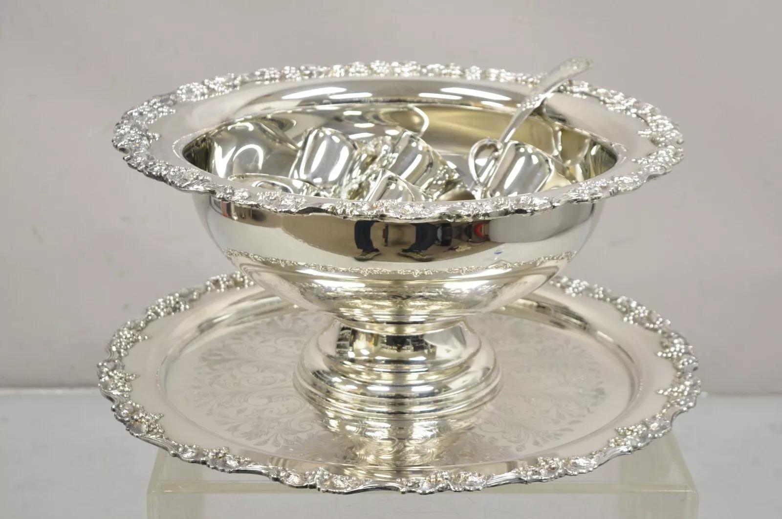 Vintage Victorian Style Silver Plated Punch Bowl Tray Set with 12 Cups - 15 pcs. Item features a grapevine pattern, 12 cups, round ornate tray/platter, large pedestal punch bowl, 1 ladle spoon, very nice vintage set. Circa Late 20th Century.