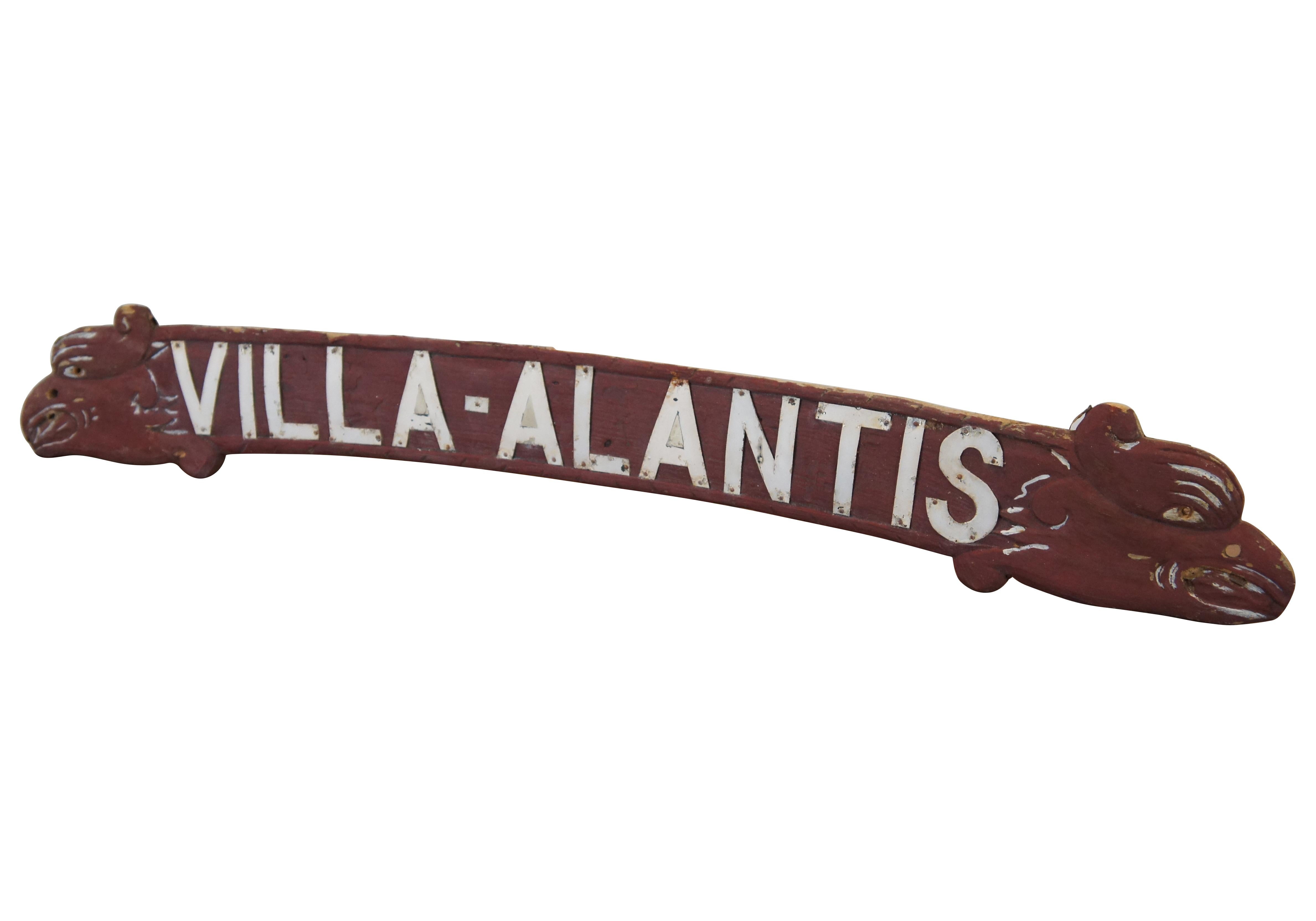 Vintage-Werbeschild aus geschnitztem Holz mit weißem Metallschriftzug für Villa-Atlantis, mit einer leicht geschwungenen Form, die mit den Köpfen von Drachen, Seeschlangen oder Adlern/Gryphen bestückt ist.