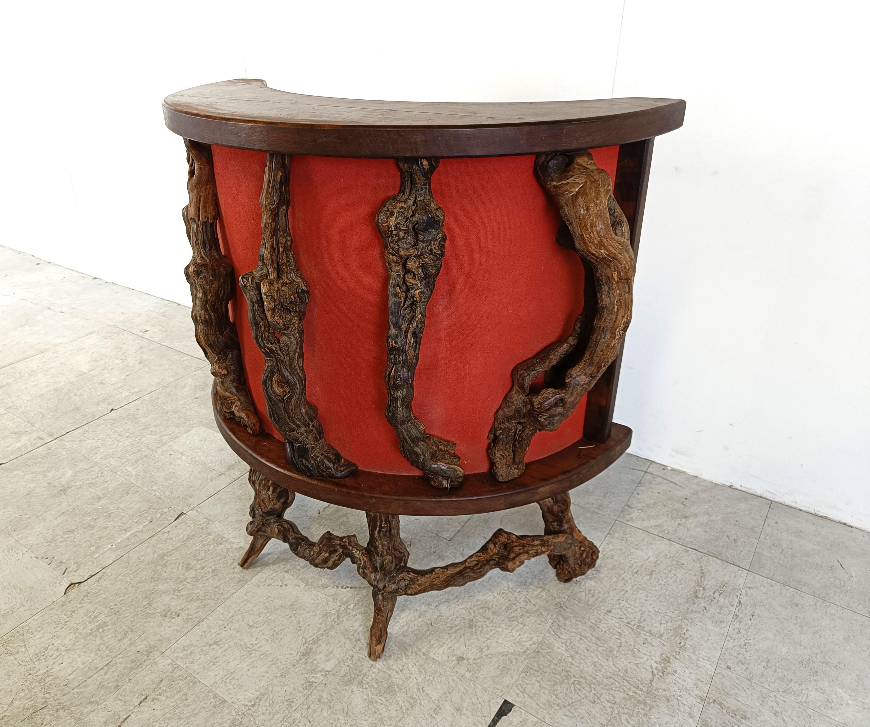 Up for sale is this rather unique bar counter made from vine wood branches.

This sculptural bar counter can be a nice decorative piece at home or a very unique piece in a wine shop.

It has a red fabric upholstered panel to beautifully contrast the