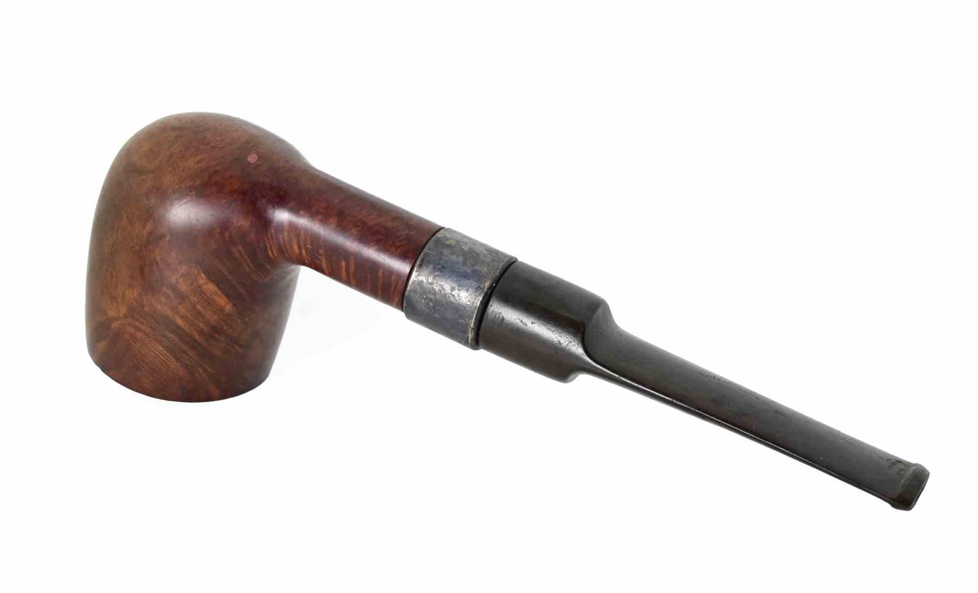 Pipa da tabacco vintage dalla classica forma a biliardo, realizzata in Inghilterra. La ciotola è cilindrica con un bordo leggermente arrotondato e presenta alcuni scurimenti dovuti all'uso. Il legno ha una finitura calda e marrone-rossastra con