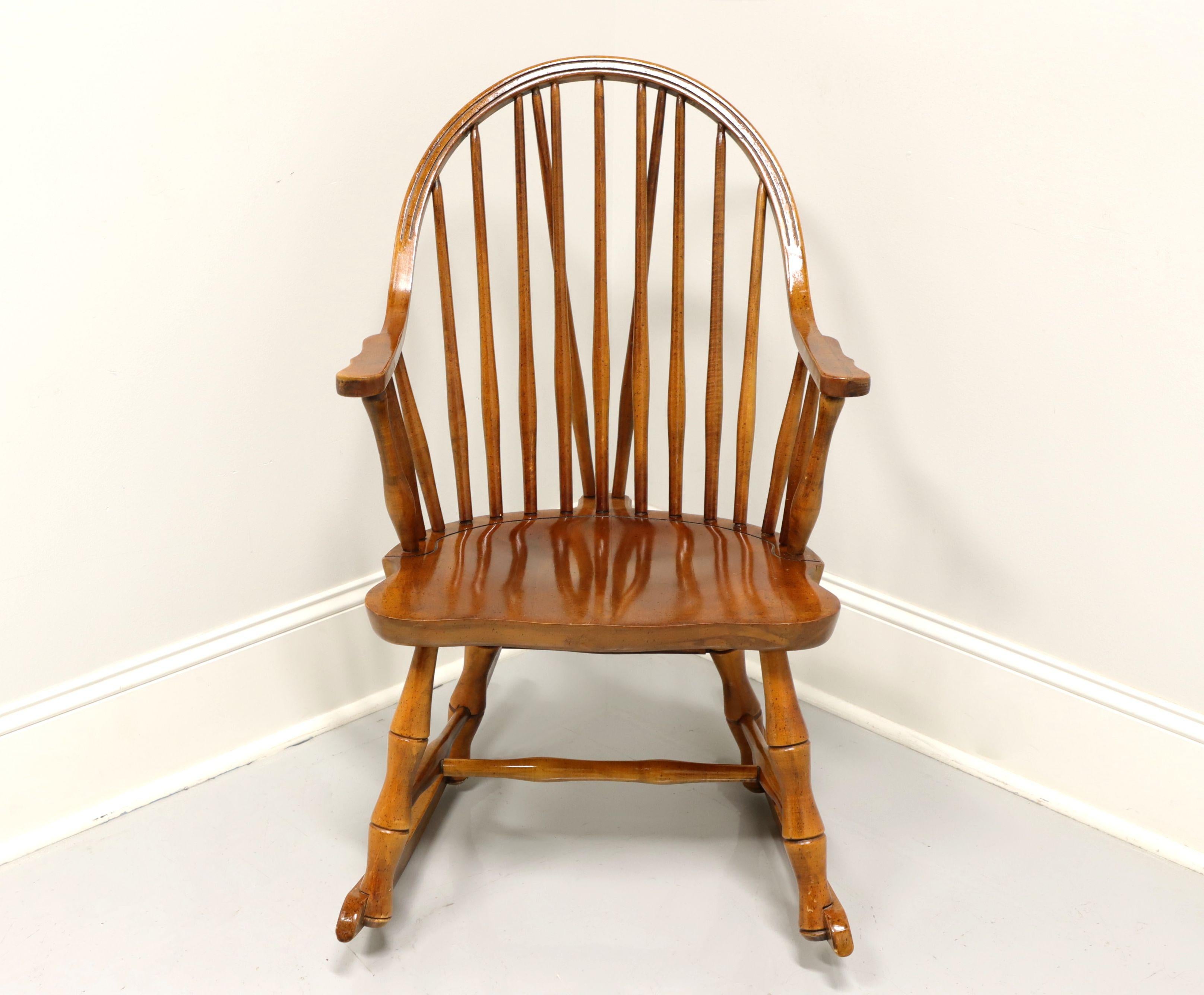 A vintage Windsor style rocking chair by Viriginia House. Solid maple with bowback, turned spindles, turned legs, stretchers and rockers. Made in Atkins, Virginia, USA, in the mid 20th Century.

Measures: Overall: 22.75 W 28 D 35 H, Seat: 20 W 16.25