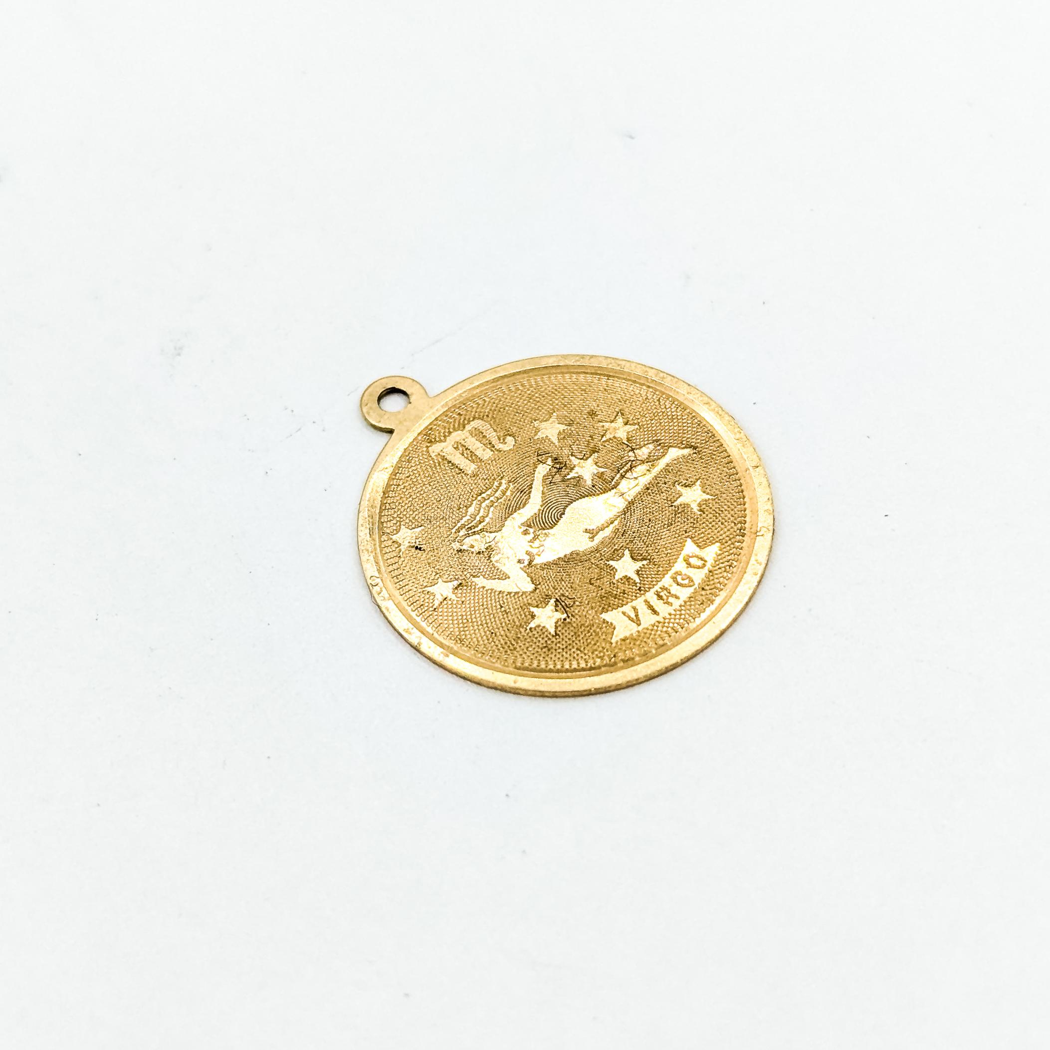 Vintage Virgo Zodiac Anhänger in 14k Gelbgold

Dieser Vintage-Anhänger ist aus 14-karätigem Gelbgold gefertigt und zeigt ein eingraviertes Jungfrauenmotiv, das die klassische Jungfrauengestalt umgeben von Sternakzenten darstellt. Der strukturierte,