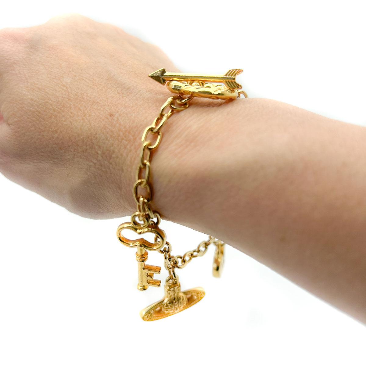 An adorable and rare Vintage Vivienne Westwood Charm Bracelet from the earlier years of the legendary brand. This bracelet tells the story of love and features symbols depicting a Putto, heart padlock, key (to my heart), arrow (to the heart) and of