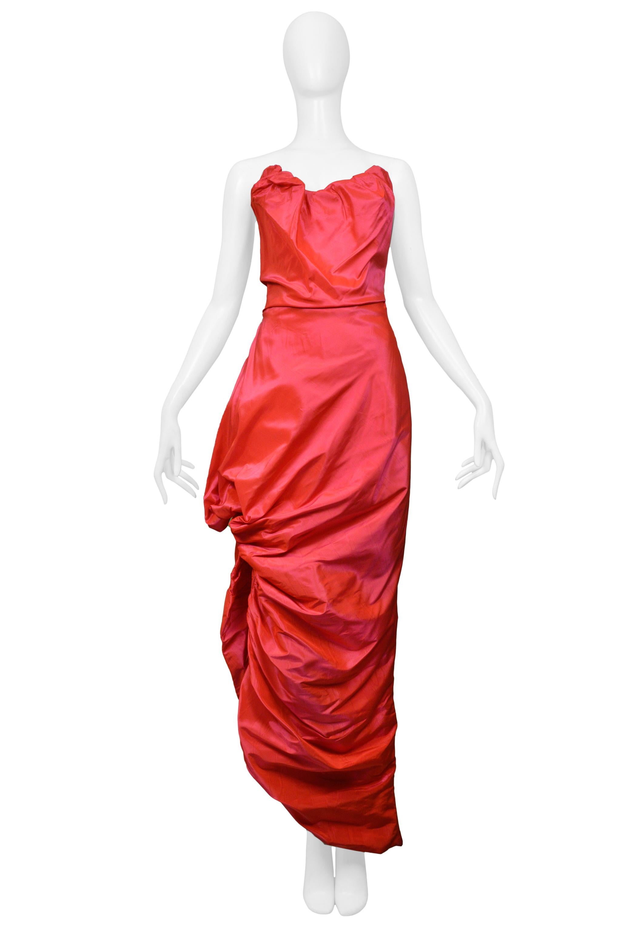 Resurrection Vintage is excited to present a vintage Vivienne Westwood hot pink taffeta strapless evening gown featuring a built-in corset bodice with zipper closure and gathered side slit creating an asymmetrical and draped skirt. 

Vivienne