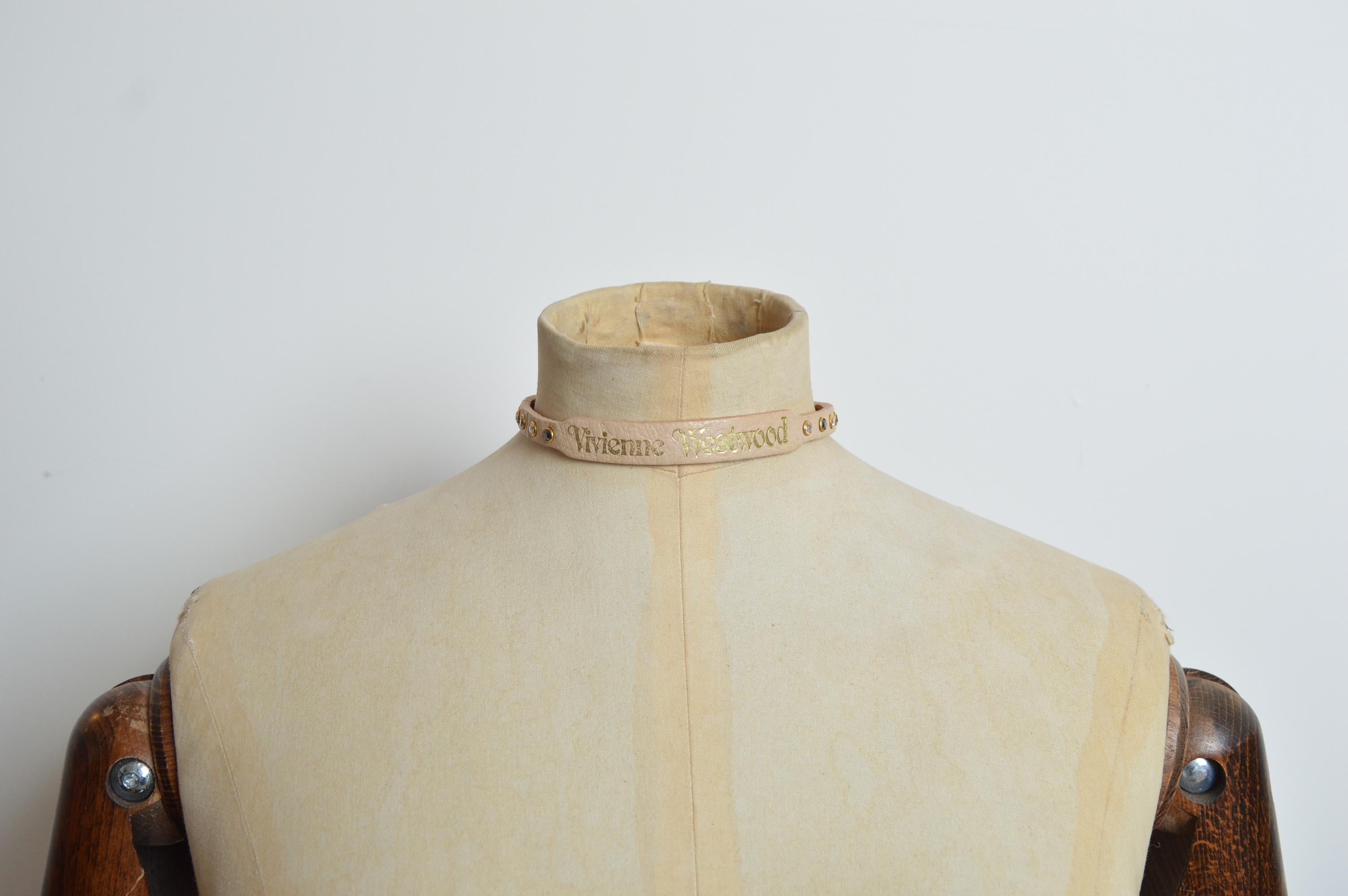 Vintage VIVIENNE WESTWOOD Tan Beige Leather & Swarovski Rhinestone Choker UNISEX Necklace. 
Features ; adjustable Buckle closure, decorative rhinestones in white and black diamonds, Large Orb circular decoration and Gold embossed Vivienne Westwood