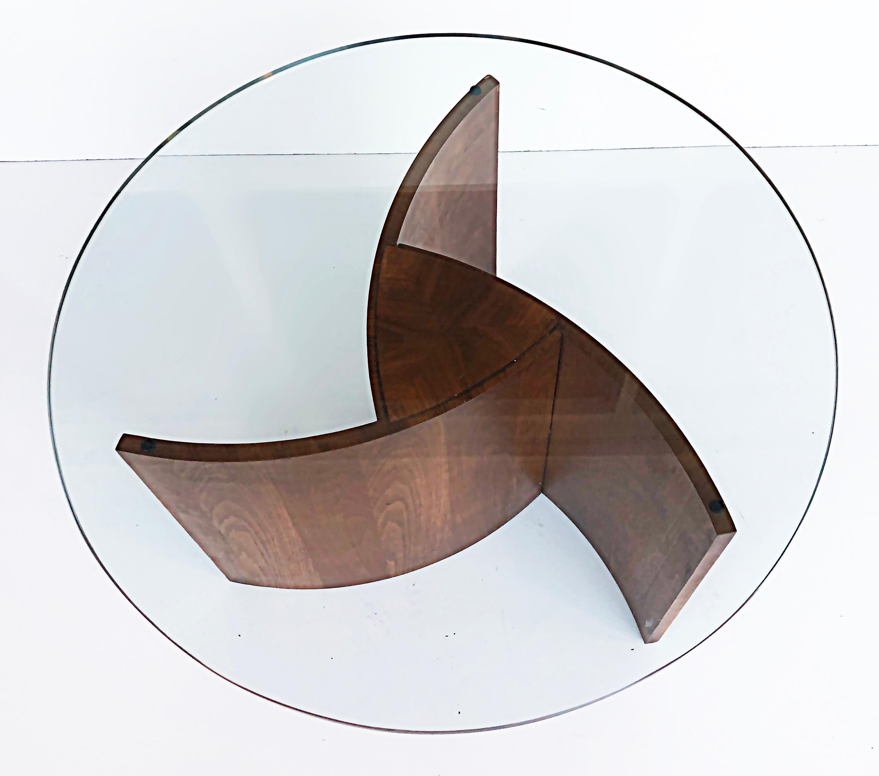 Vintage Vladimir Kagan Propellor form walnut coffee table with glass top, 1960s 

Offered for sale is a rare circa 1965 Vladimir Kagan (1927-2016) coffee table in walnut that has three curved fins that swirl as a propellor would. The table is