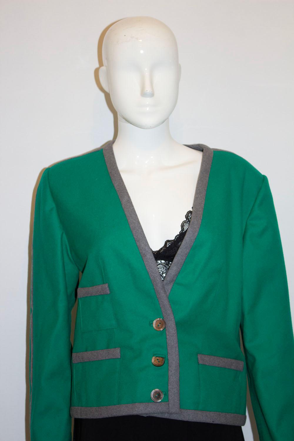 A wonderful vintage jacket by Vogue America, in a head turning colour combination of grey and green.
The jacket has a v neckline with three button fastening and three buttons on the front.  It is fully lined and has a colourful stripe along the side