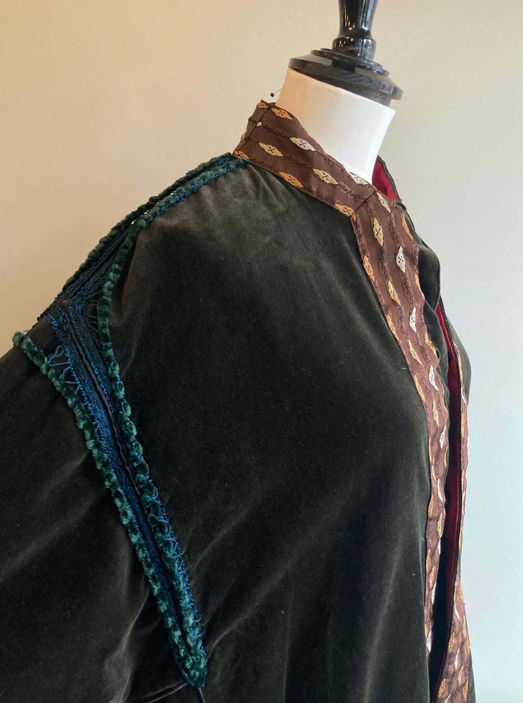 Vintage olive green velvet jacket from Voyage London by Louise and Tiziano Mazelli. 

Beautiful velvet jacket with brown, white and gold silk trim around the hemline, cuffs, collar and opening. Embellished with green and teal stitching along the