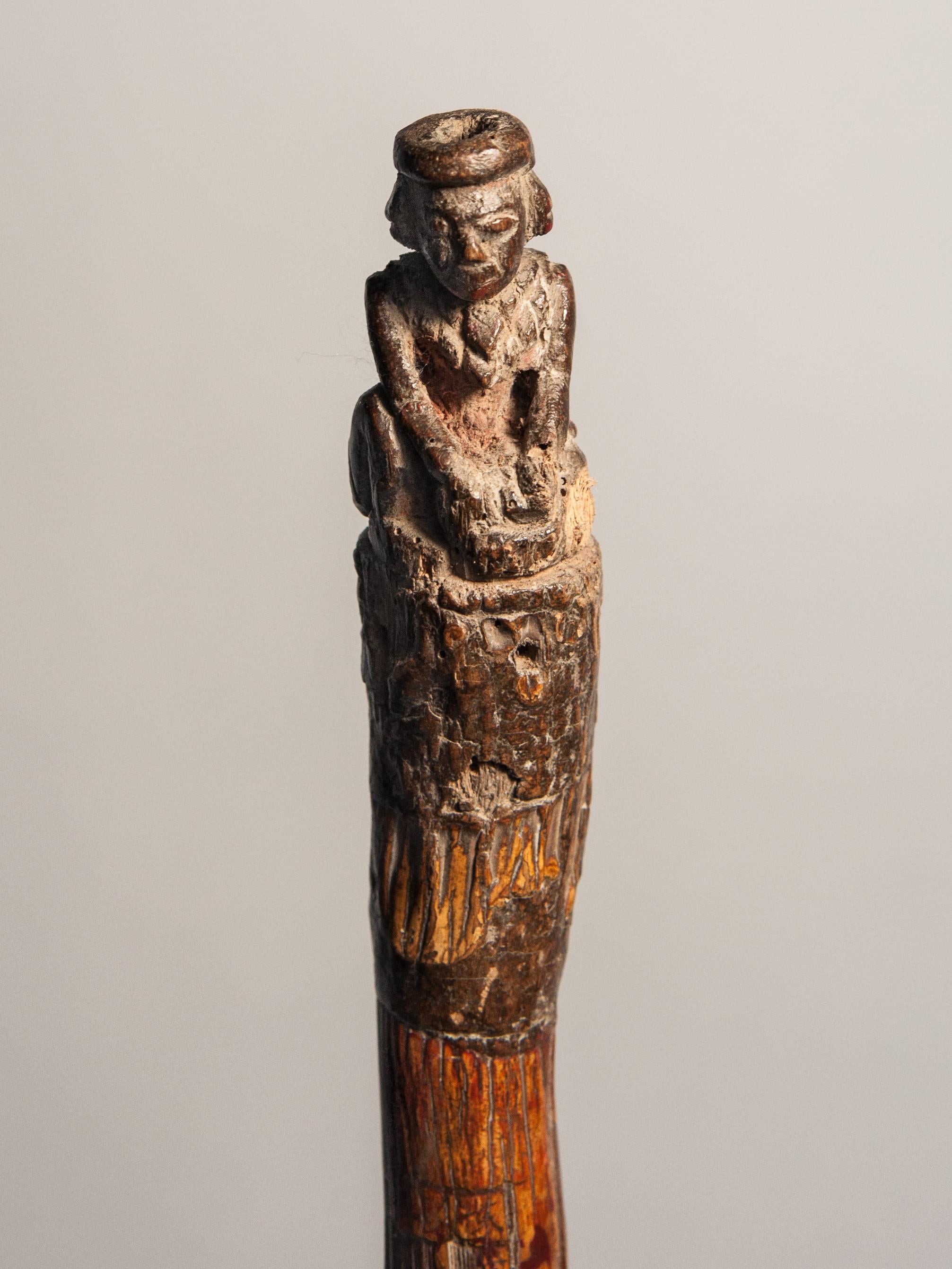 Vintage bamboo walking stick with carved figure, from Burma, early 20th century. Mounted on a wooden stand.
Condition: The piece is in fair to good condition. It is strong and structurally stable. The features of the carved figure have lost some of