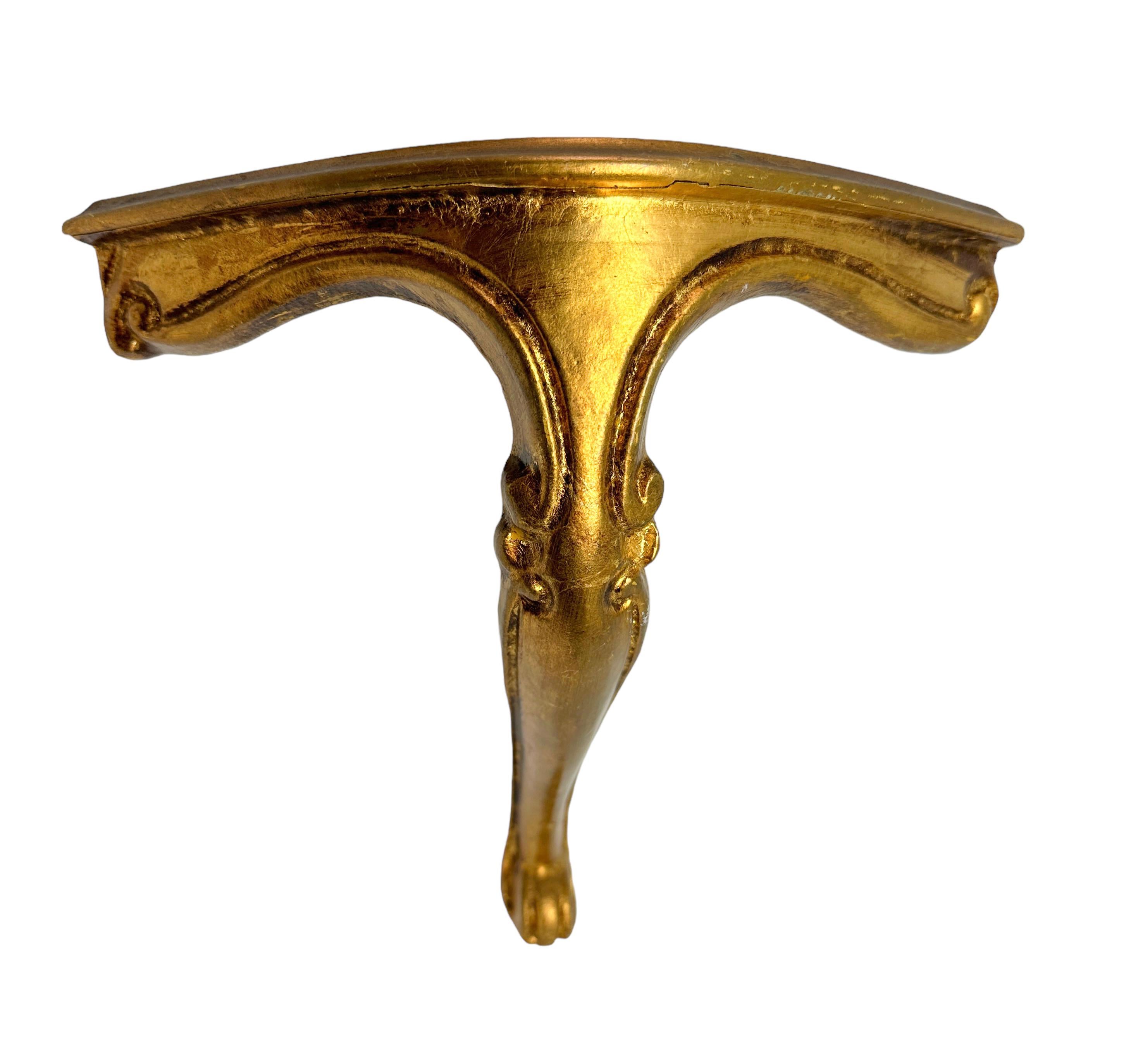 Offered is an absolutely stunning, 1960s Italian giltwood wall corner shelf or wall console. Minor patina and paint lost gives this piece a classy statement. Made of hand carved wood and gold plated. A nice shelf to present a statuette or a
