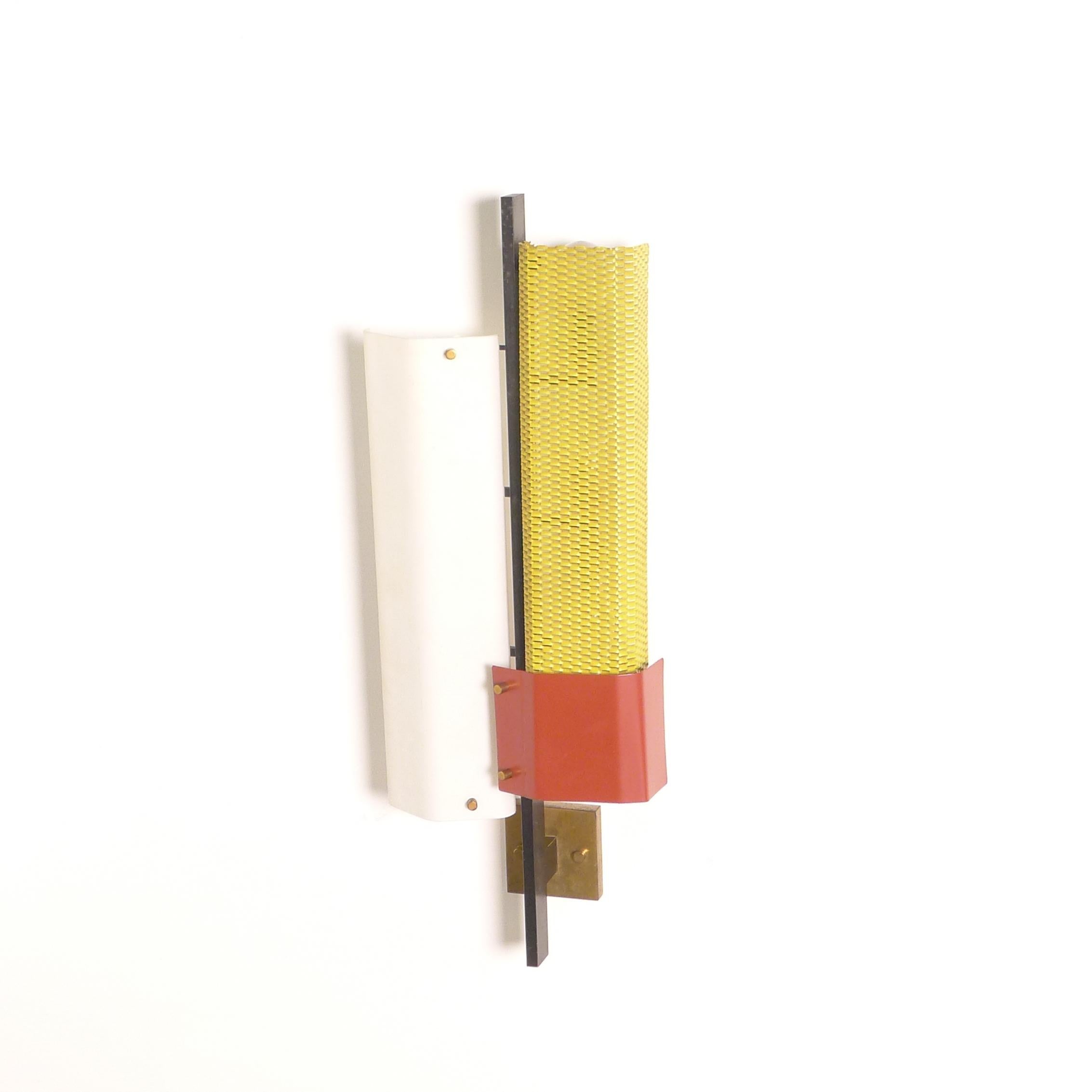 Original 1950s vintage wall light or sconce, made by Lumi and likely designed by Oscar Torlasco.

Constructed with a white painted metal panel and a yellow painted metal mesh panel with red base to each side of a metal support, with brass rivets and