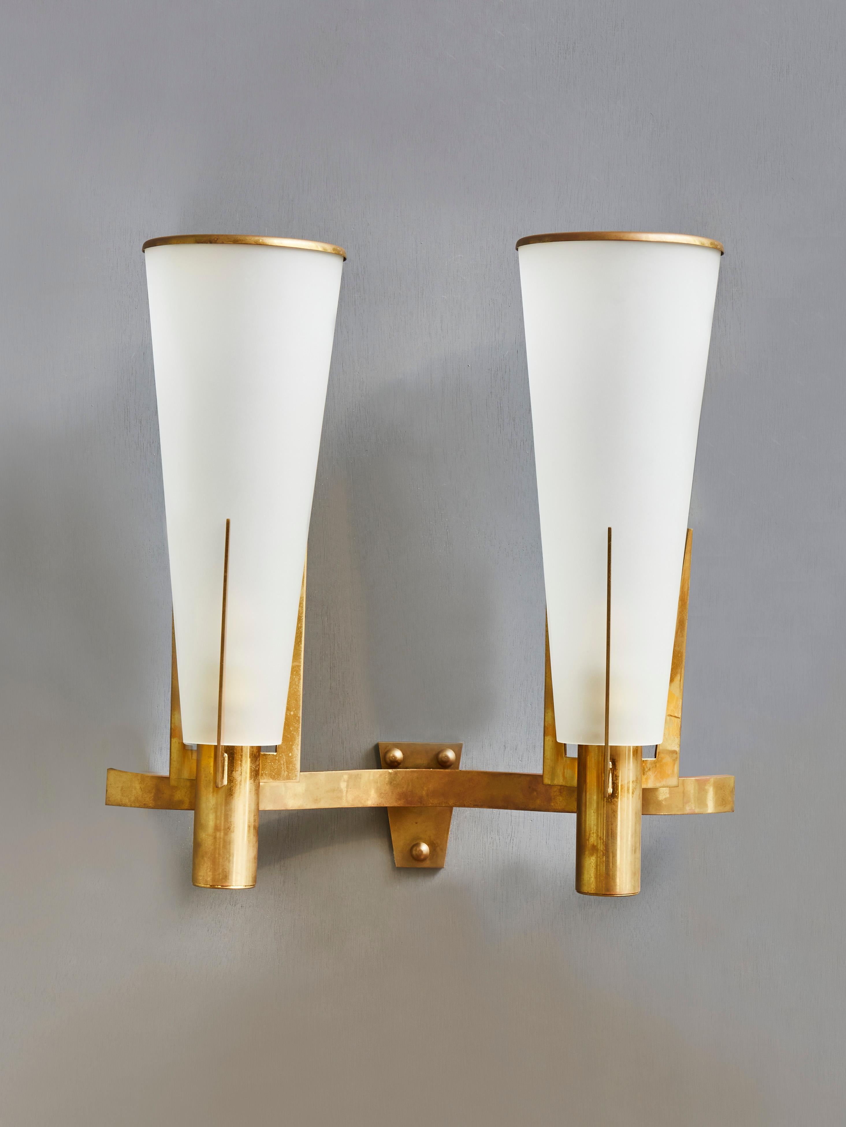 Elegant pair of vintage wall sconces made of brass and opaline glass. Designed by Stilnovo. 
2 light bulbs. 
Italy, 1960s.