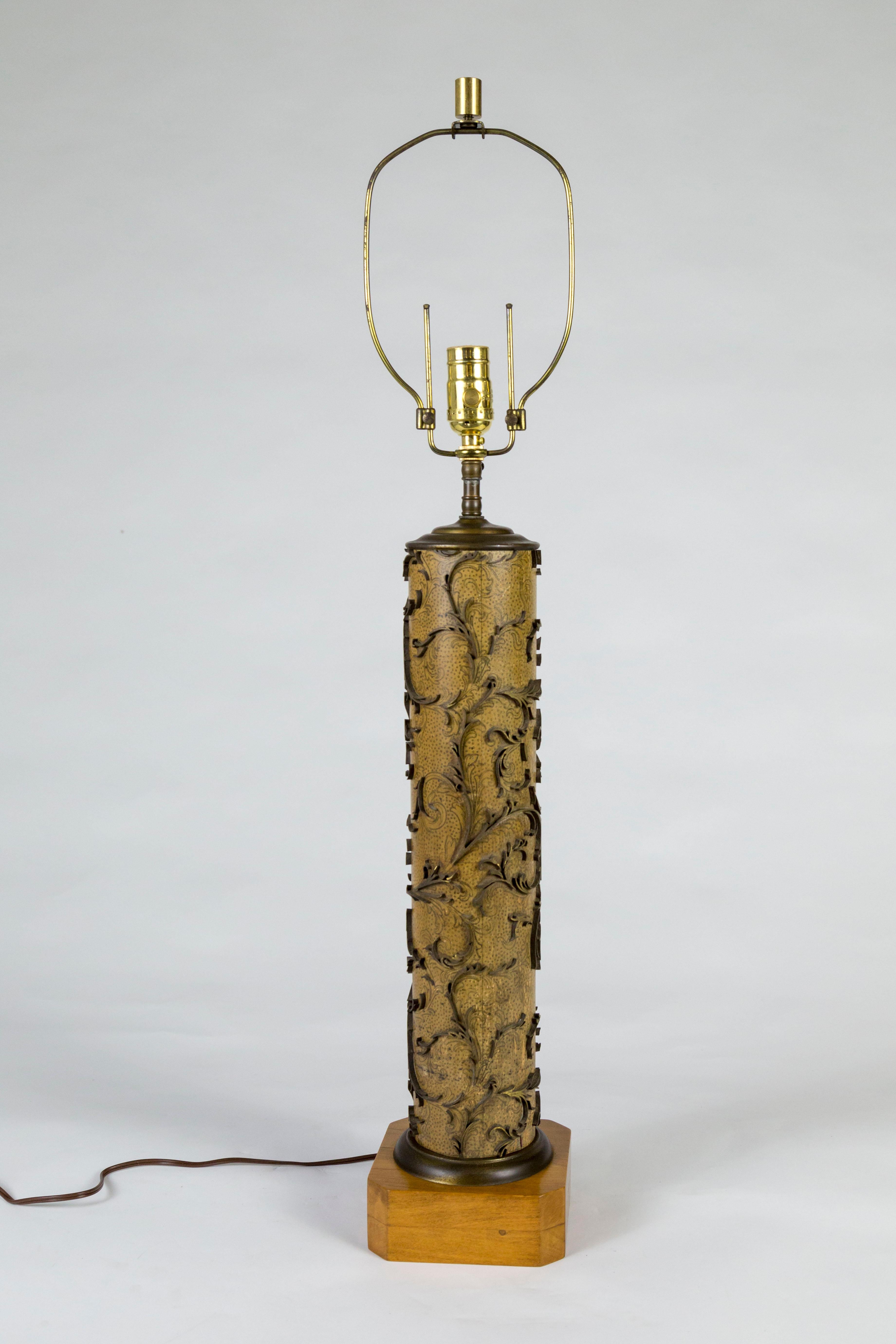A lamp made from a vintage roller for printing wallpaper. The imprinting elements are brass swirling leaves; mounted on a square, wooden base; adjustable harp, newly wired with a dimmer on the socket. Measures 6