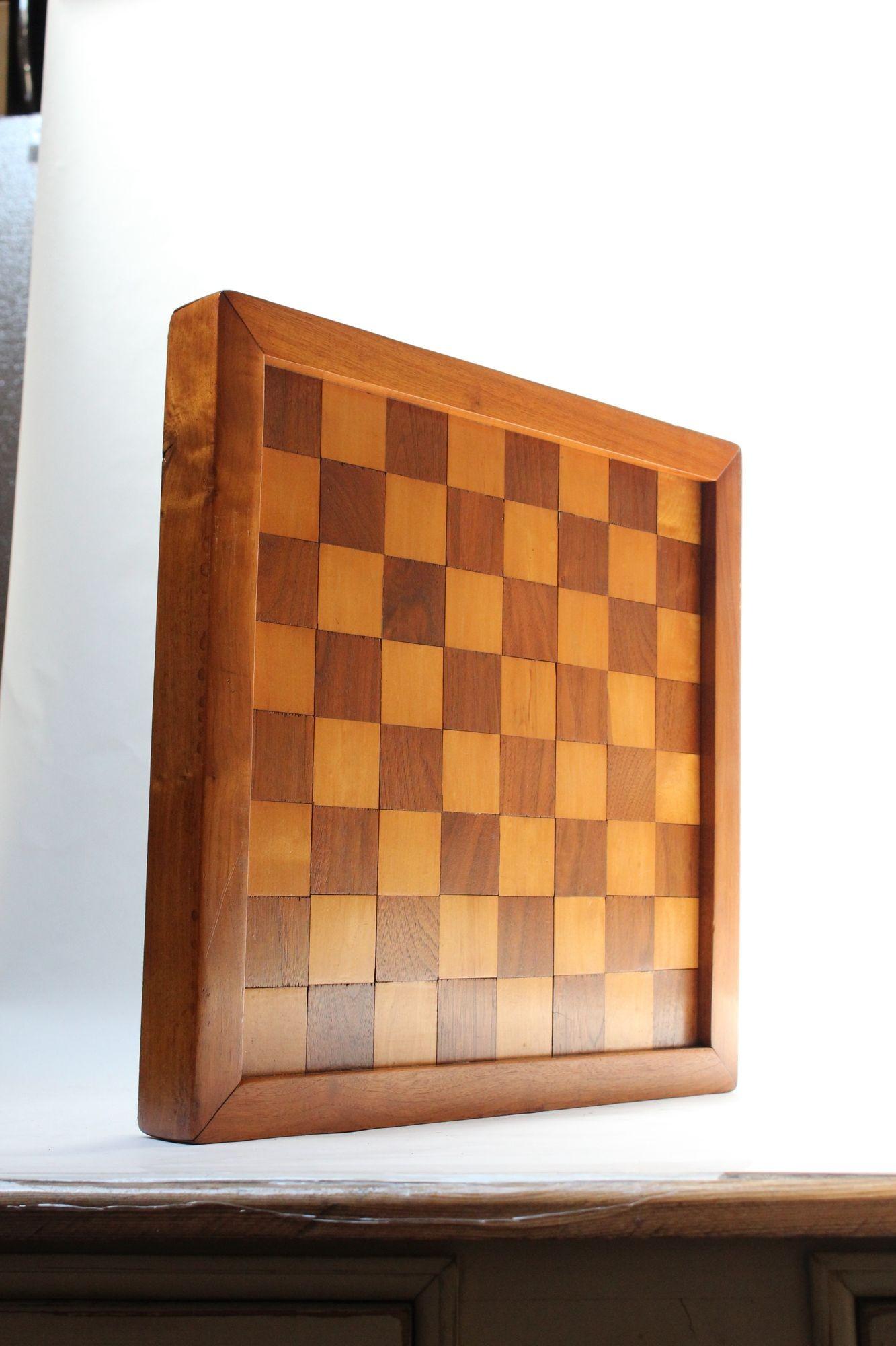 Deeply inset solid walnut and beech chess / checkerboard within a carved walnut border (ca. 1970s, USA). Dense board is supported by cylindrical feet, all green felted for table protection.
Good, vintage condition with light wear consistent with age