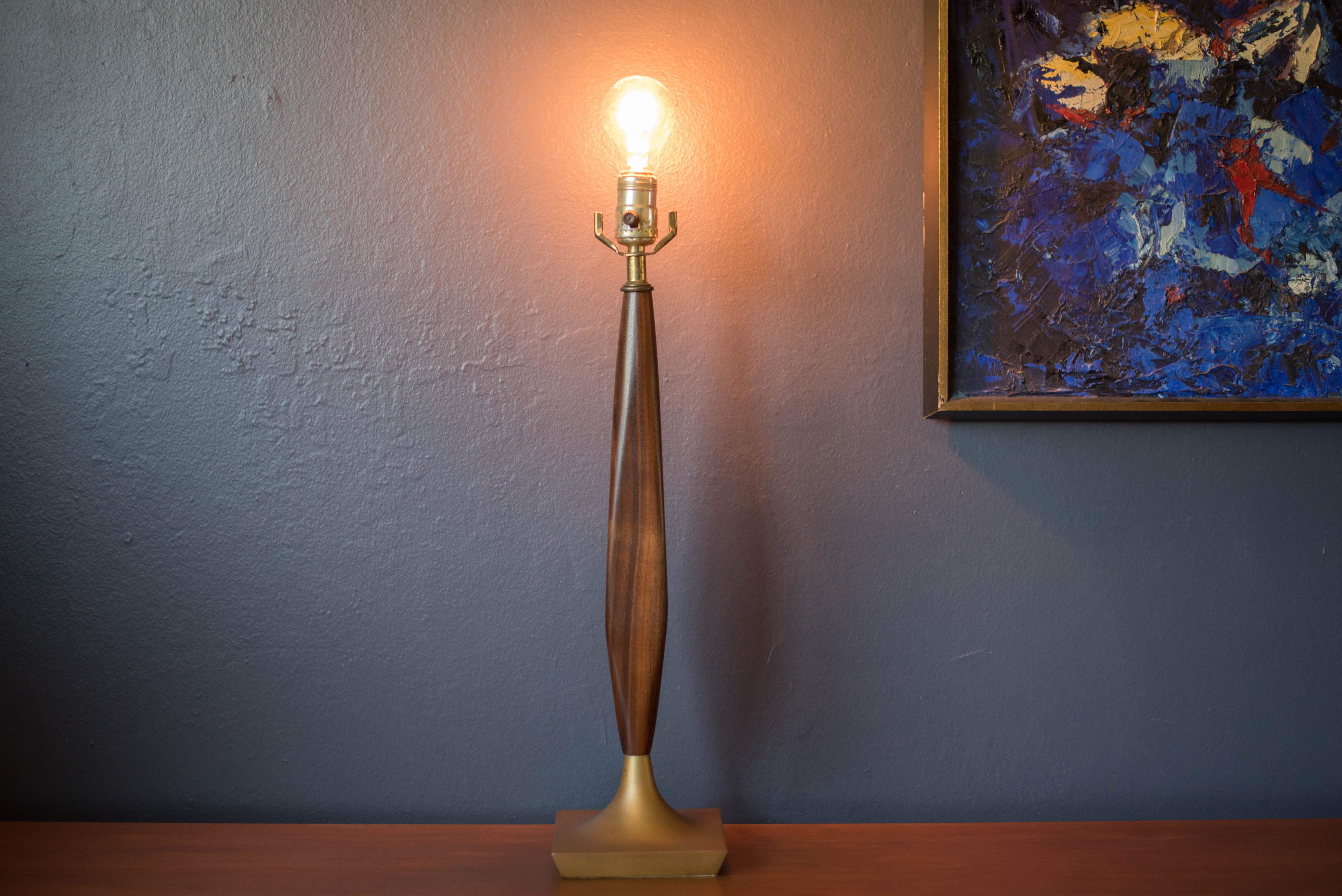 Mid-Century Modern accent table lamp circa 1960s This piece features a sculptural walnut stem and a brass base. Includes a three-way switch.