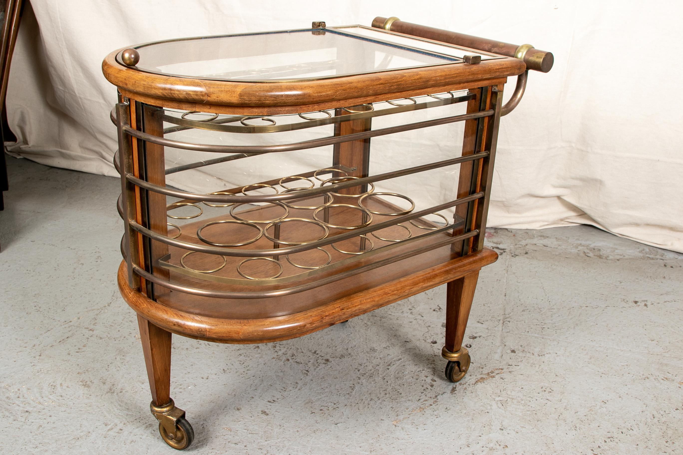 Vintage walnut and bronze bar cart, U-shaped walnut and brass banded frame with curved glass sides, lift up glass top with bronze banding, and a narrow mirror top panel at the back. Opens to two tiers of brass circles to hold the bar ware and