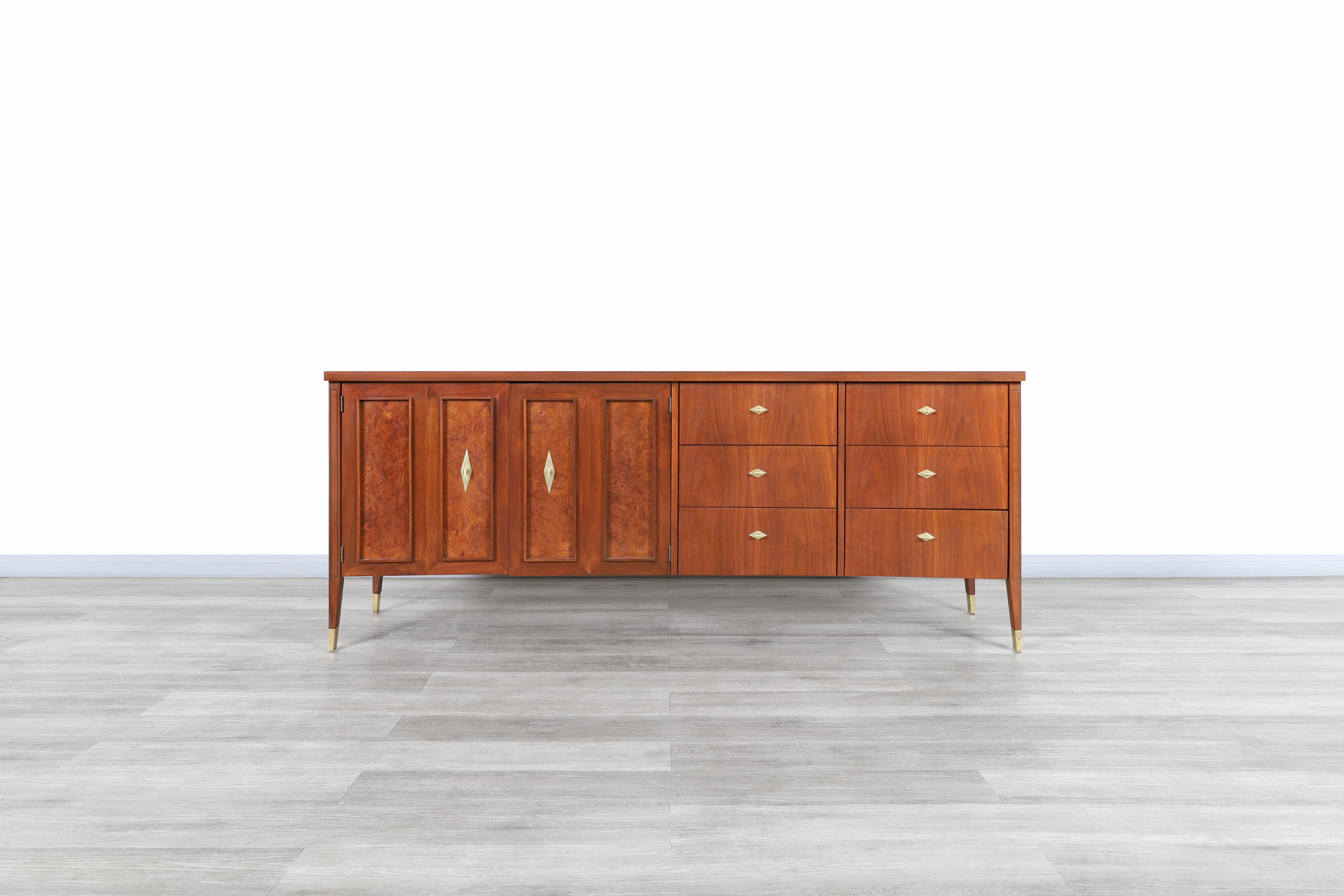 Splendida credenza d'epoca in noce e radica, progettata e prodotta negli Stati Uniti, intorno agli anni '50. Questa credenza ha un design curvo nella sua struttura, che le permette di distinguersi dal resto e allo stesso tempo di offrire una vista