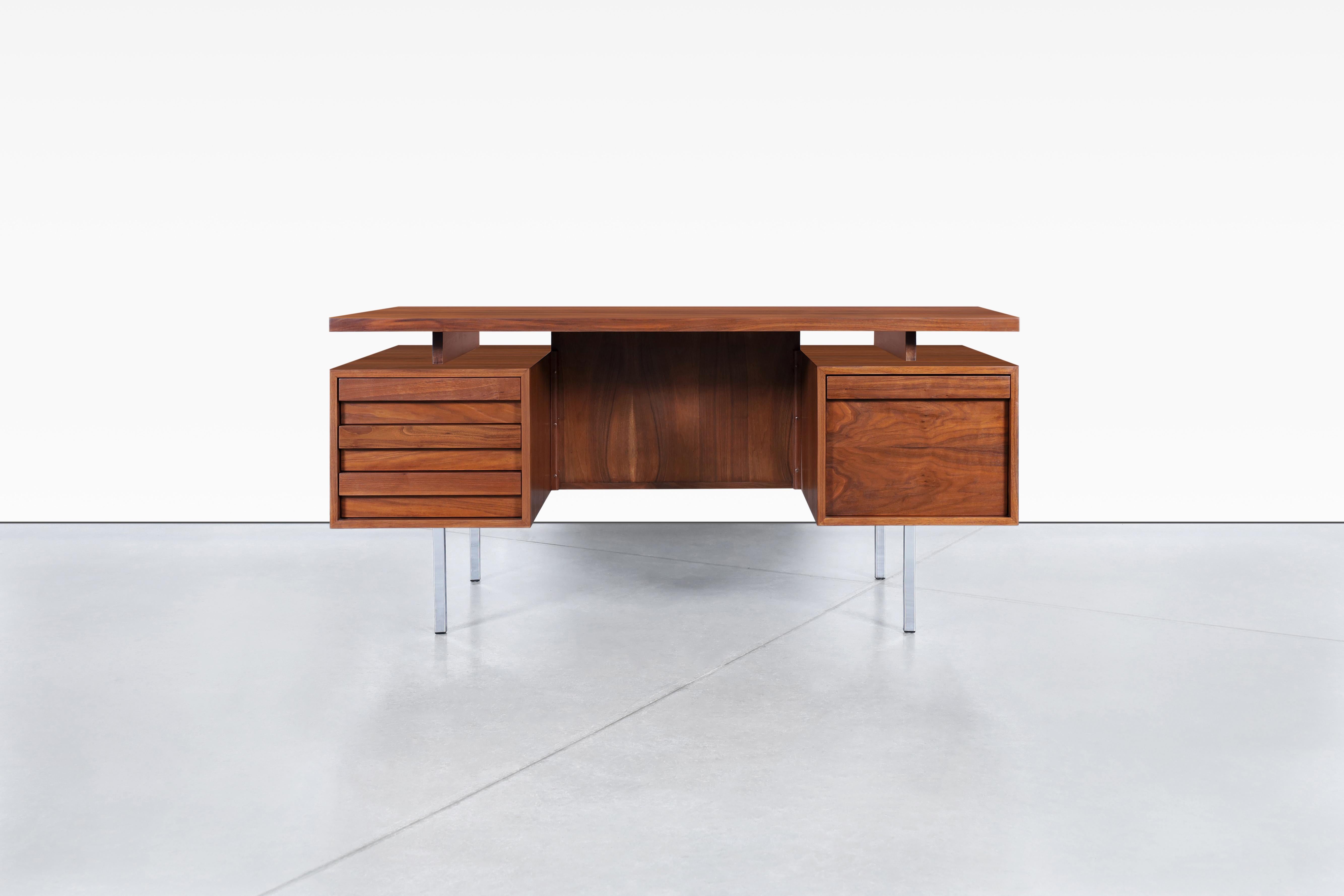 Questa scrivania direzionale di metà secolo, disegnata da John Keal per Brown Saltman negli anni '50, è un pezzo senza tempo che unisce funzionalità e stile. L'ampia superficie di lavoro e il design del piano flottante lo rendono un'aggiunta pratica