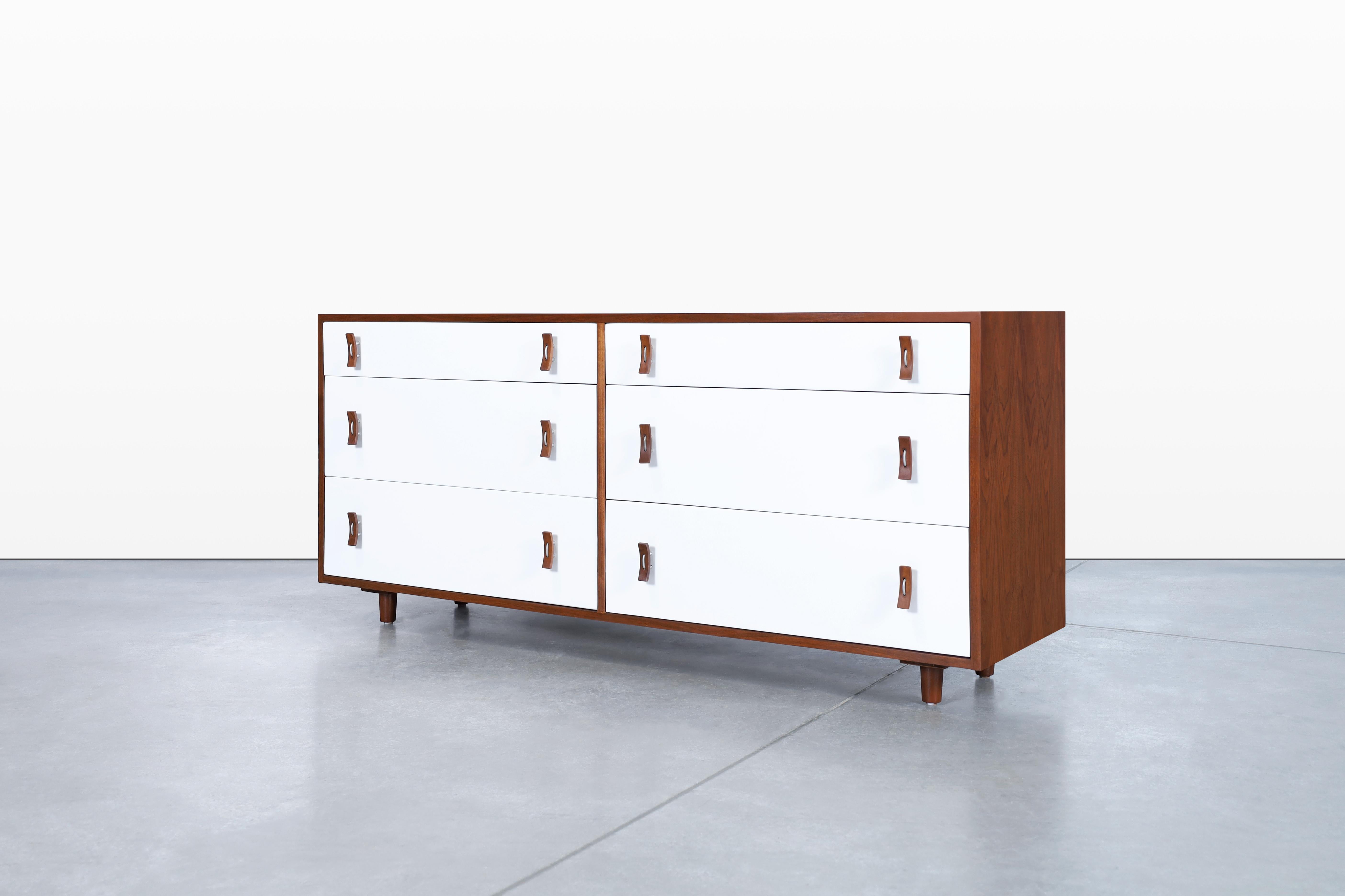 Fabulous vintage walnut and lacquered Dresser by Stanley Young for Glenn of California in the United States, circa 1950s. This dresser has a minimalist but highly functional design, where the elegant contrast of colors stands out. It features six