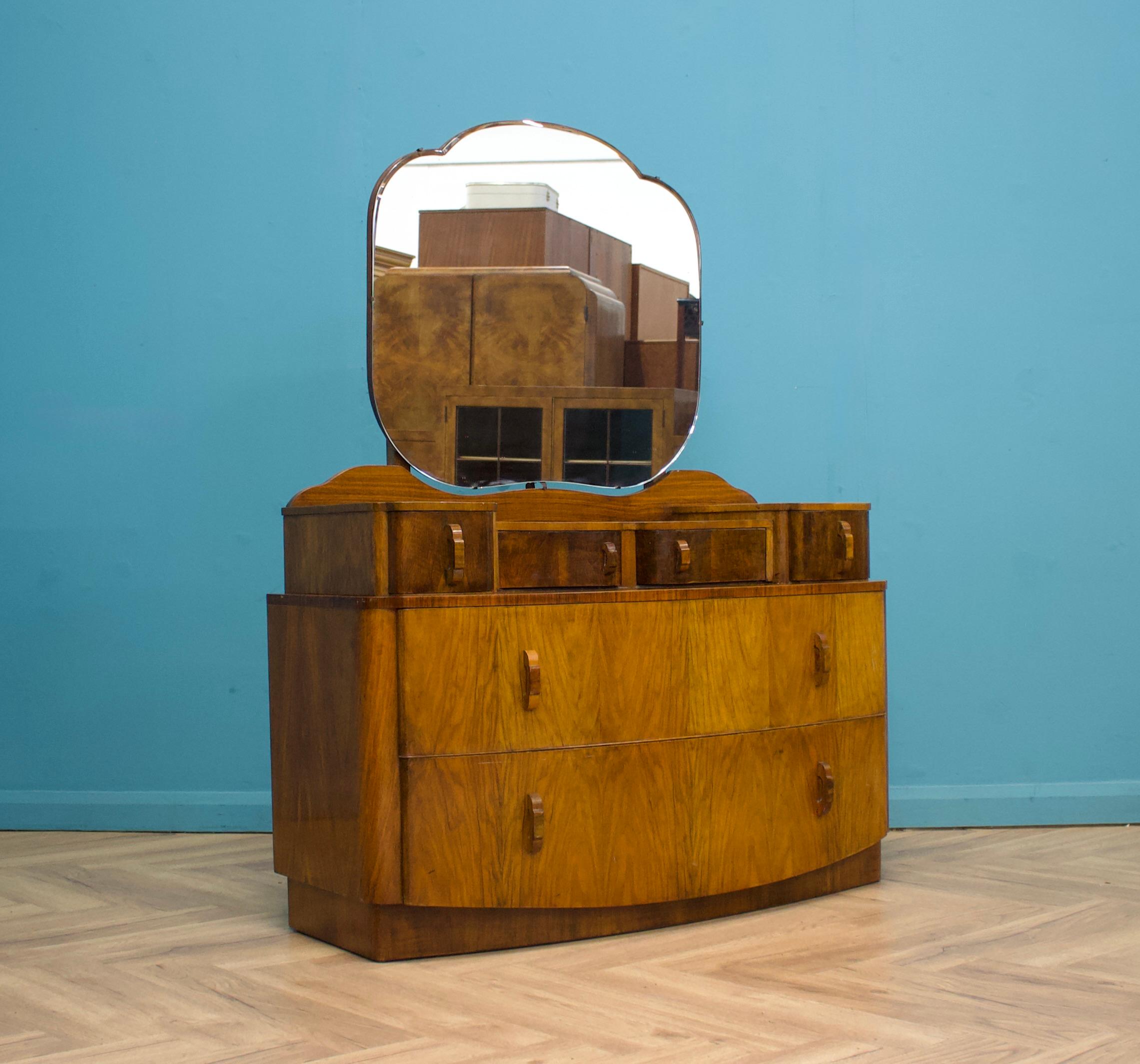 Commode en noyer Art Déco   - vers les années 1930
Avec un grand miroir au milieu
Il y a six tiroirs au total 
 
La hauteur du miroir est de 153 cm.
