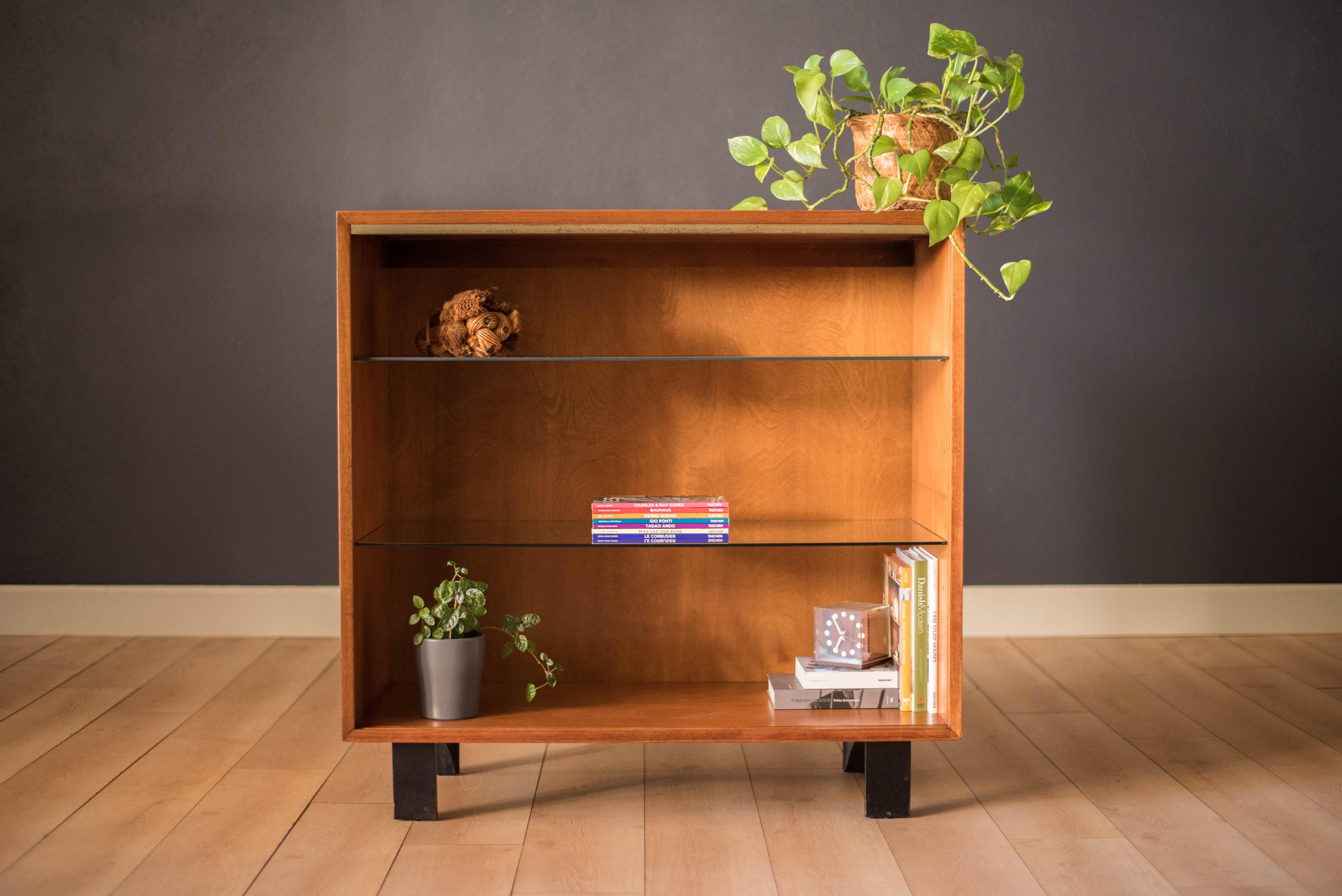 Mid-Century Modern display bookcase designed by George Nelson for Herman Miller in walnut, circa 1950s. This piece is part of the Basic Cabinet Series (BCS) that offers plenty of storage including two adjustable glass shelves. This simple and