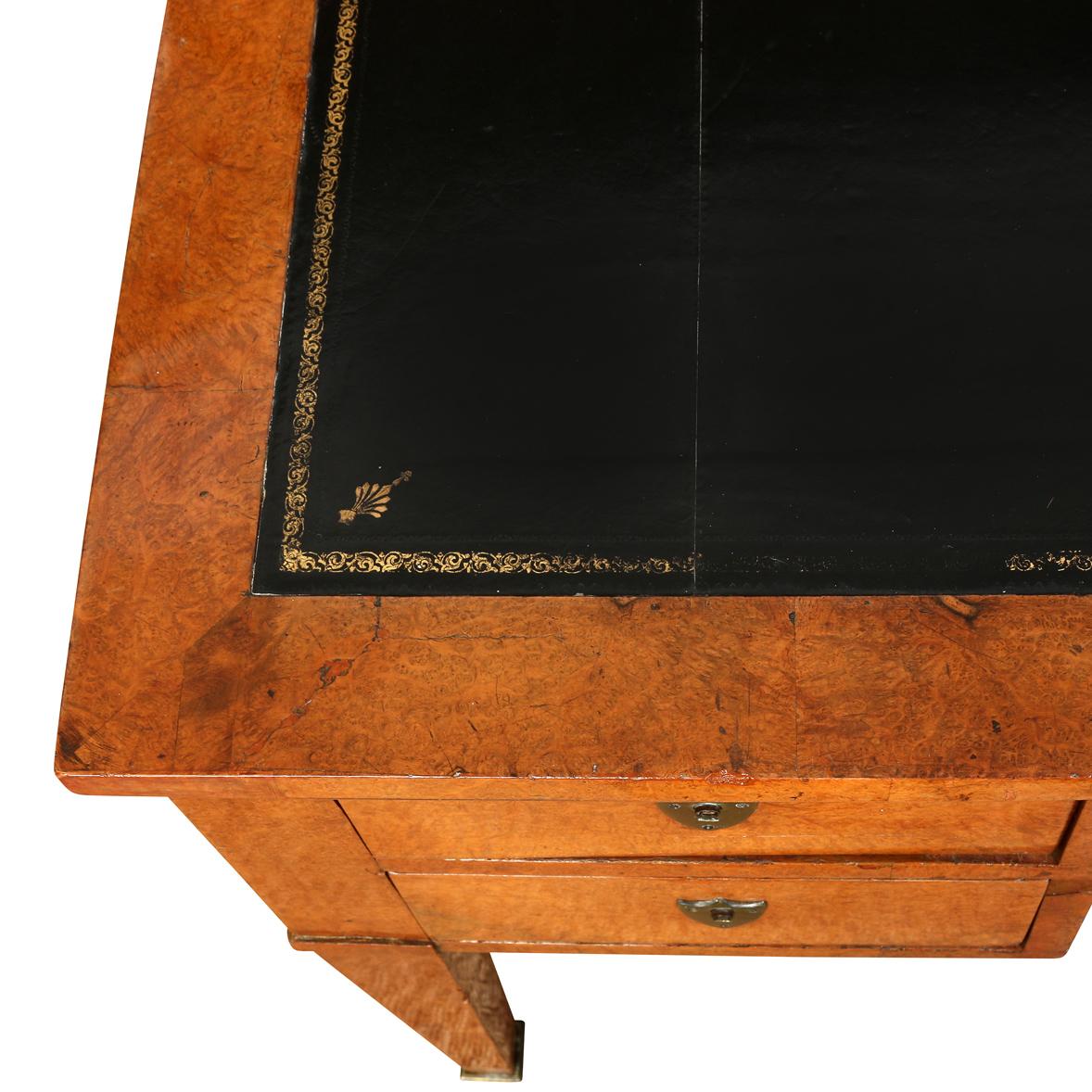 A vintage walnut Biedermeier writing desk with an embossed leather inlay top. The Biedermeier style, known for its clean lines and simplicity, is elegantly showcased in this writing desk. The design is both classical and versatile, making it