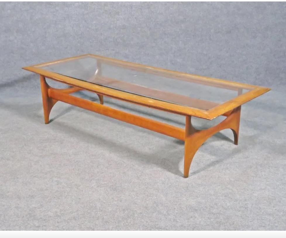 Cette table basse vintage présente un design élégant combinant des cadres en noyer et des plateaux en verre. Des bases artistiquement sculptées et un plateau carré minimal font de ce design recherché d'Adrian Pearsall un véritable joyau de la