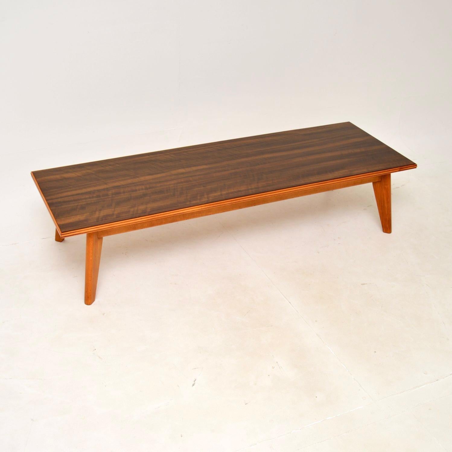 A sleek and stylish vintage walnut coffee table by Peter Hayward for Vanson. It was made in England, and dates from the 1950-60’s.

The quality is outstanding, this is low and long, sitting on beautifully tapered legs. The walnut top has a deep and