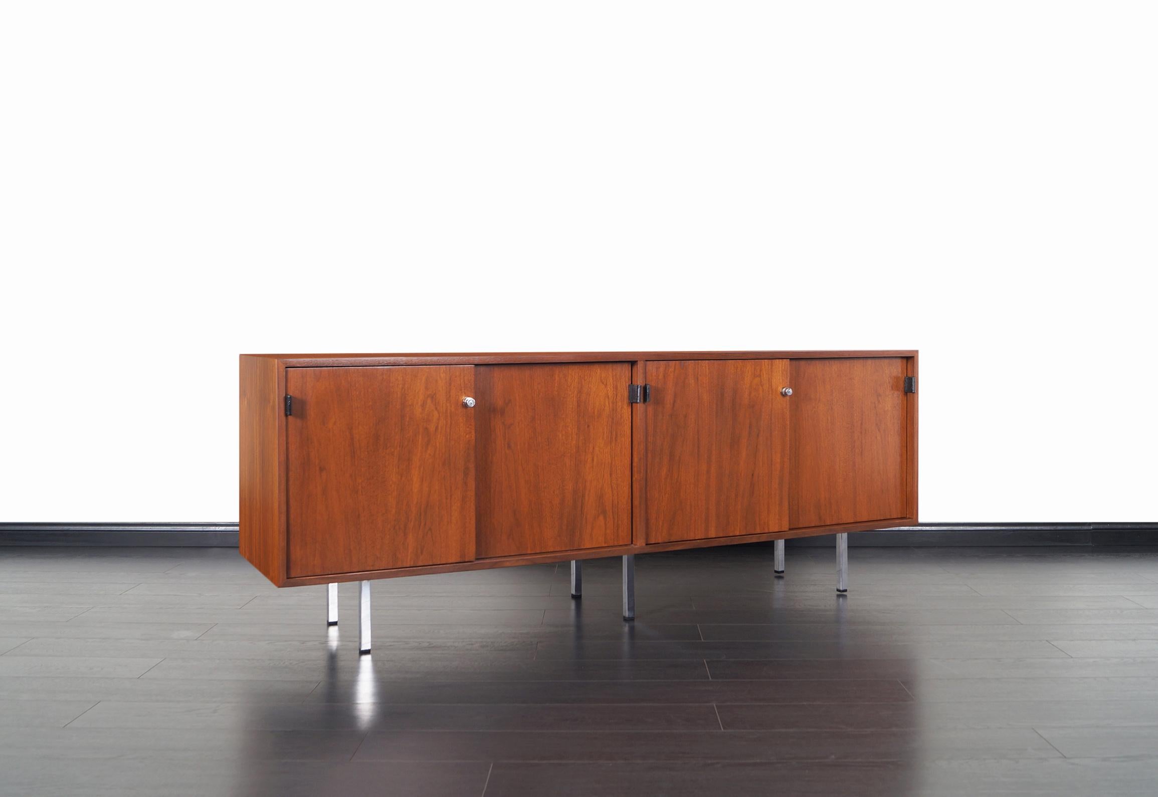 This gorgeous vintage walnut credenza was designed by Florence Knoll for Knoll International. The interior consists of four dovetail drawers, file drawer, pull-out shelf, and two adjustable shelves. Original leather pulls and key included.