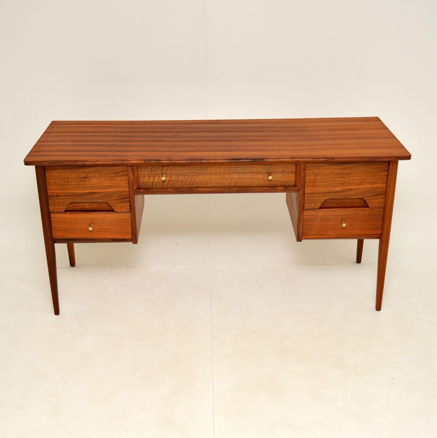 A beautifully styled vintage desk in walnut. This was made in England by A. Younger, it dates from the 1960’s.

The quality is great, this has a gorgeous colour and stunning grain patterns.

The condition is excellent for its age, it has been