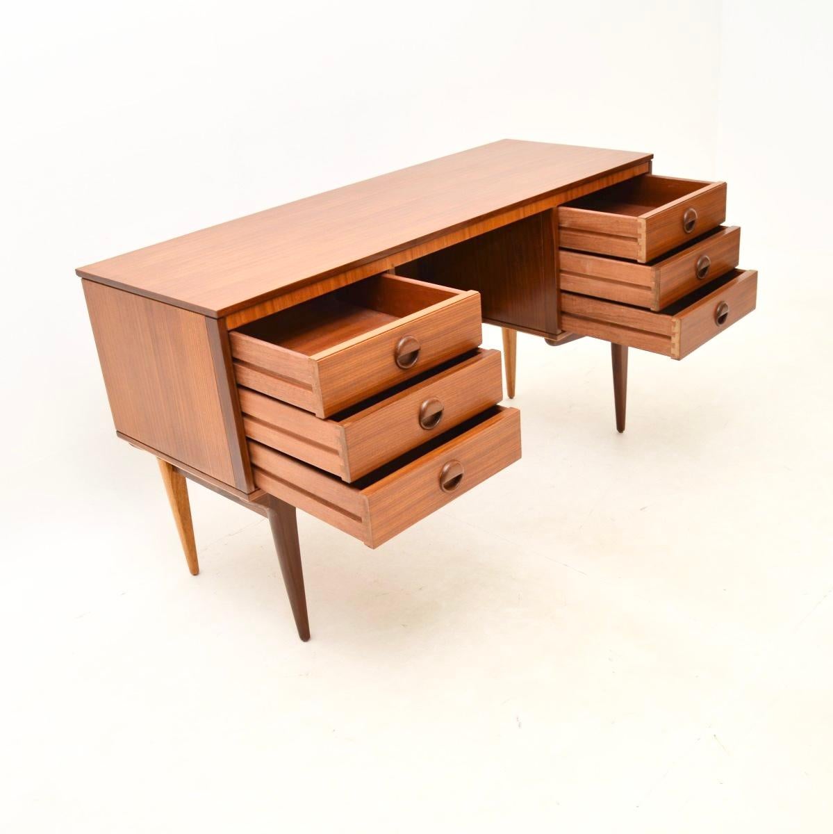 A stylish and very practical vintage walnut desk, made in England and dating from the 1960’s.

The quality is superb, this is beautifully designed with lovely round sculptural handles and stylish tapered legs. The walnut has a beautiful colour tone