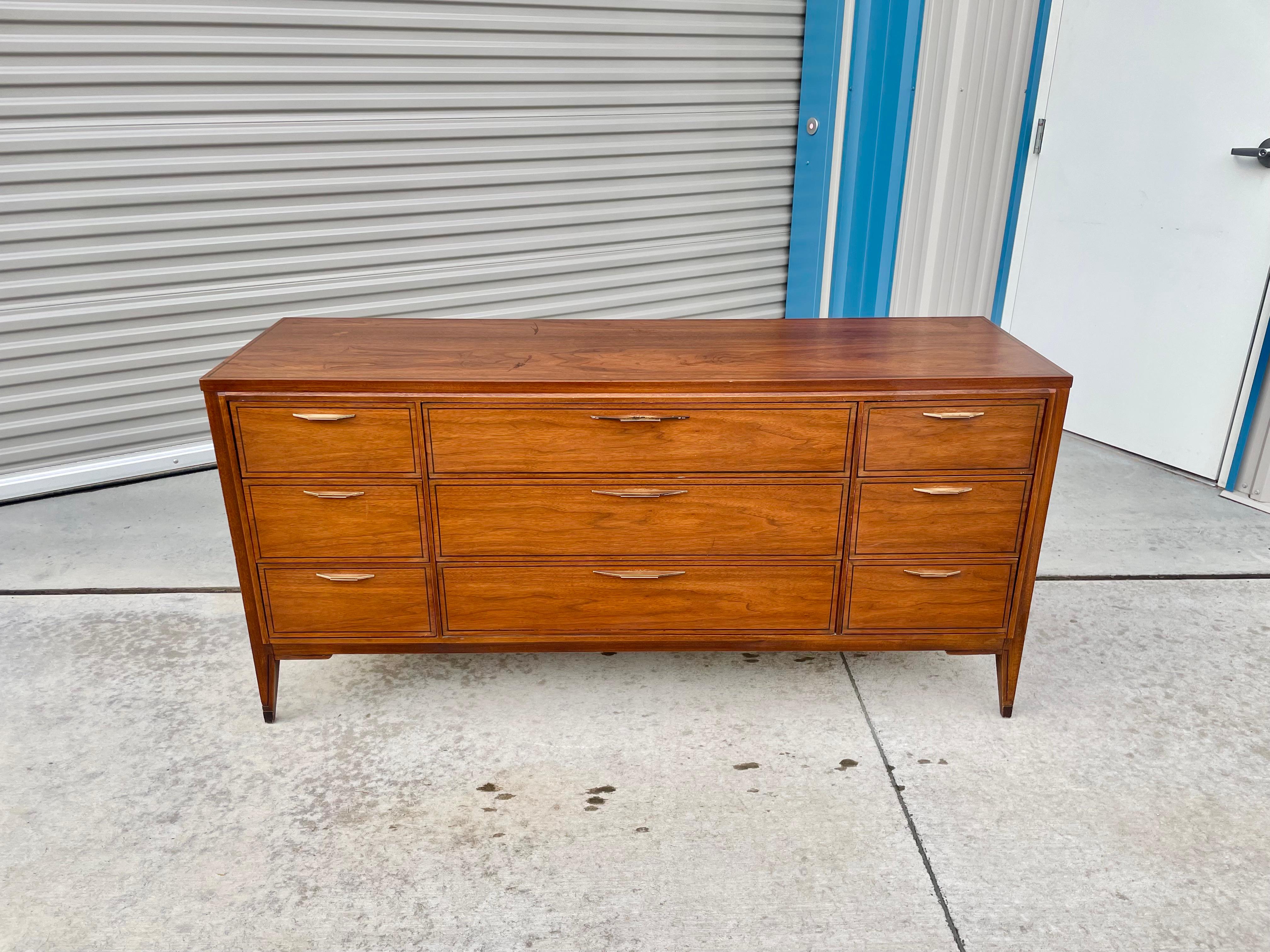 Vintage walnut dresser designed and manufactured by Kent Coffey Tempo in the united states circa 1960s. This beautiful mid-century dresser features a walnut frame giving it an excellent color tone and design. The dresser also features nine pull-out