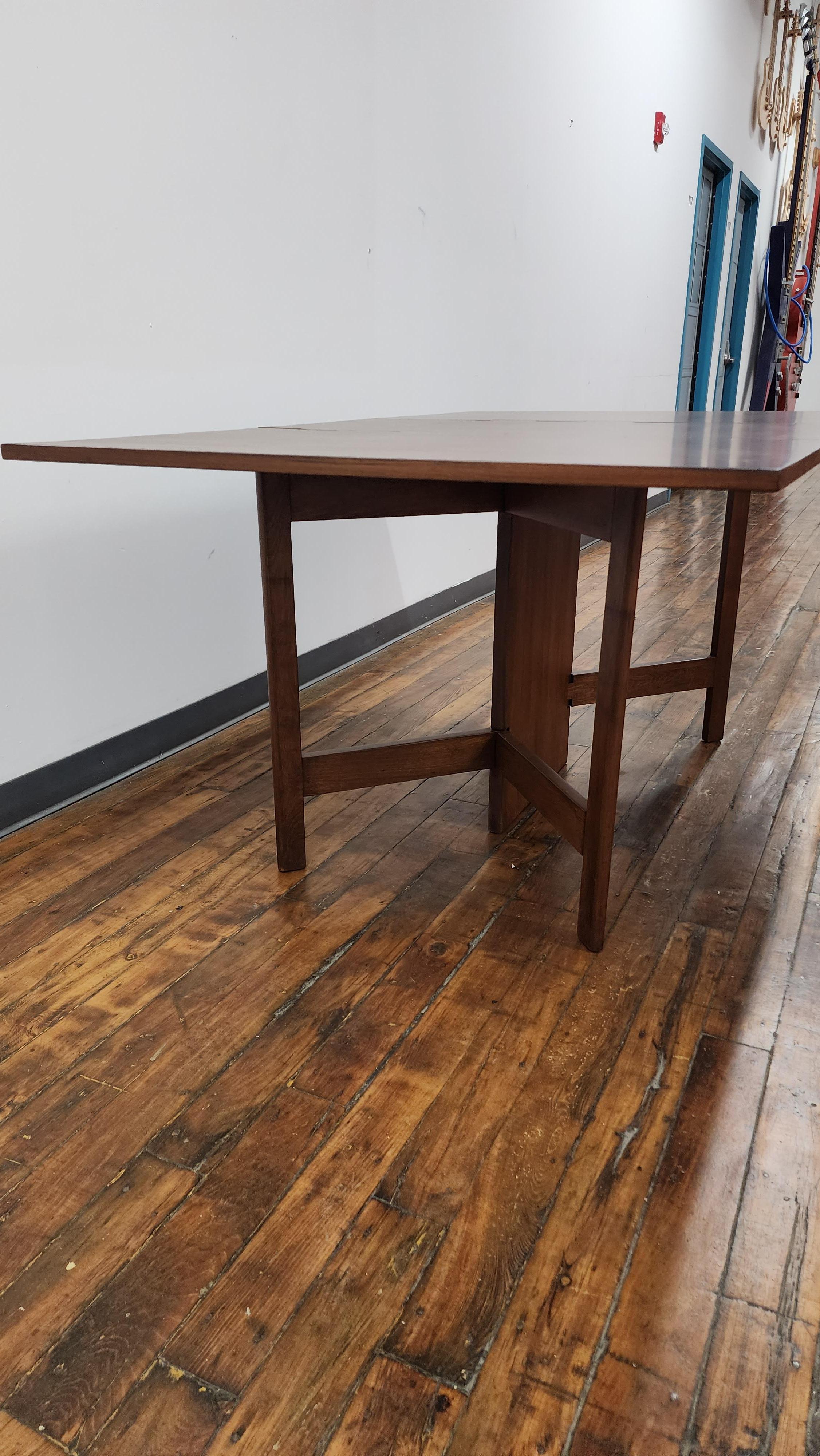 Beautiful walnut drop leaf table by George Nelson for Herman Miller.   Top has been refinished. dimensions while fully expanded are 29.75h x 40d x 64.75w. with the leaves down it is 29.75h x 40d x 18.5w.