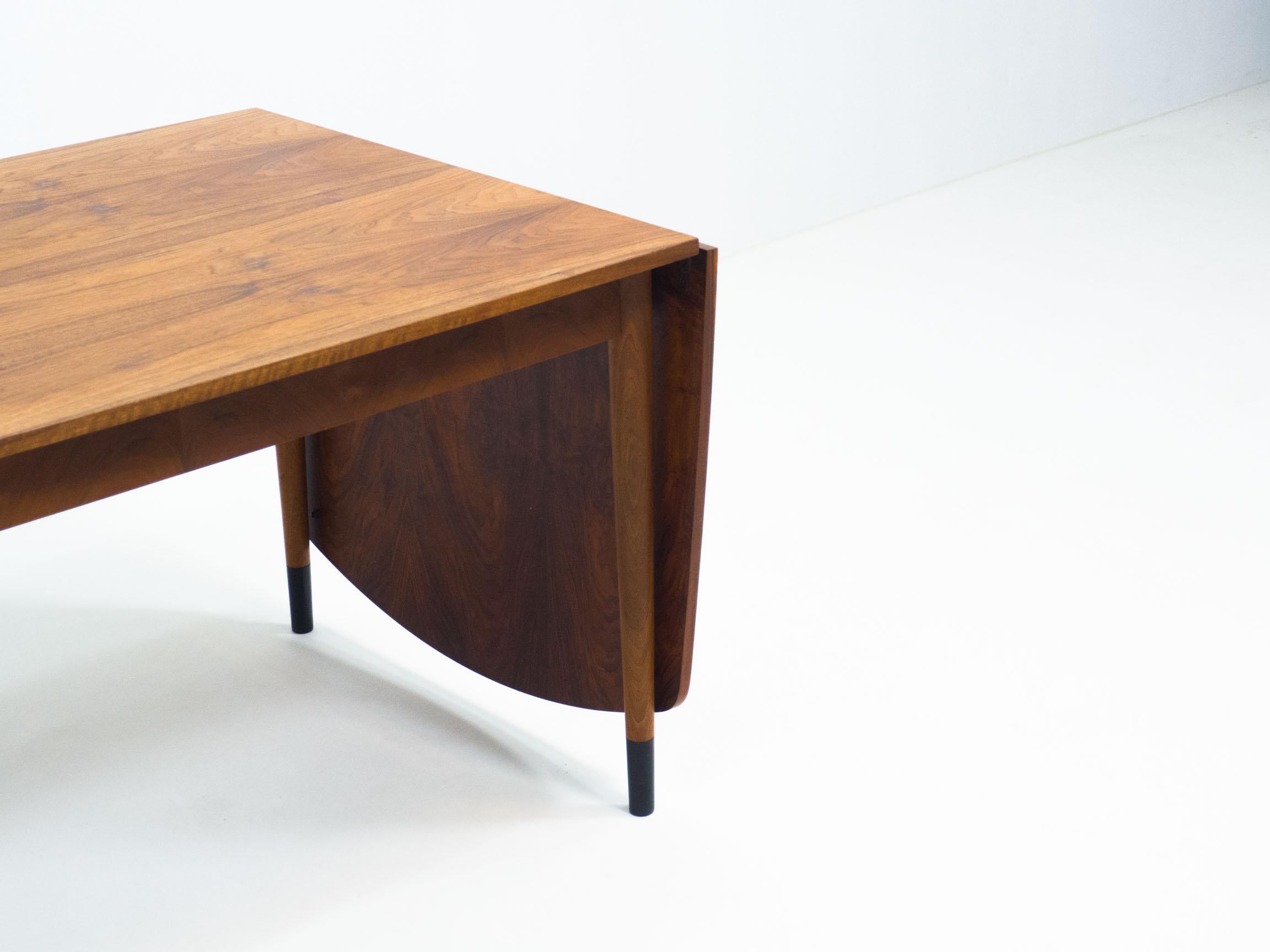 Vintage drop leaf table with lovely organic shapes.

This table has a curve througout the edges. This makes the design look very organic. The surface has been veneered with walnut veneer. The legs have dark stained ‘socks’.

The table has been