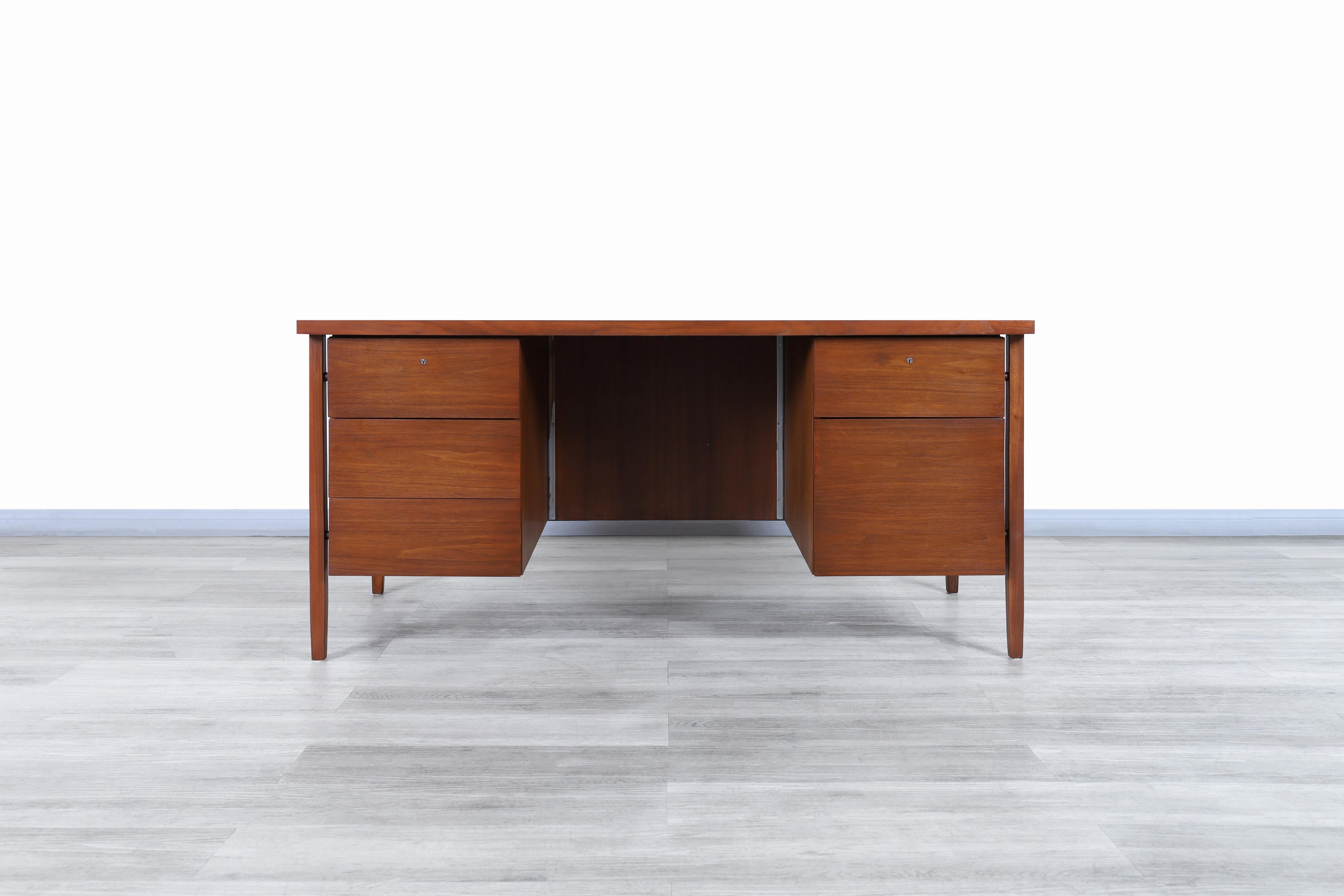 Exceptional vintage walnut executive desk designed by Florence Knoll for Knoll Associates Inc. in the United States, circa 1950s. This stunning desk, also known as model-1503, is made of walnut and features two rectangular cases that fit perfectly