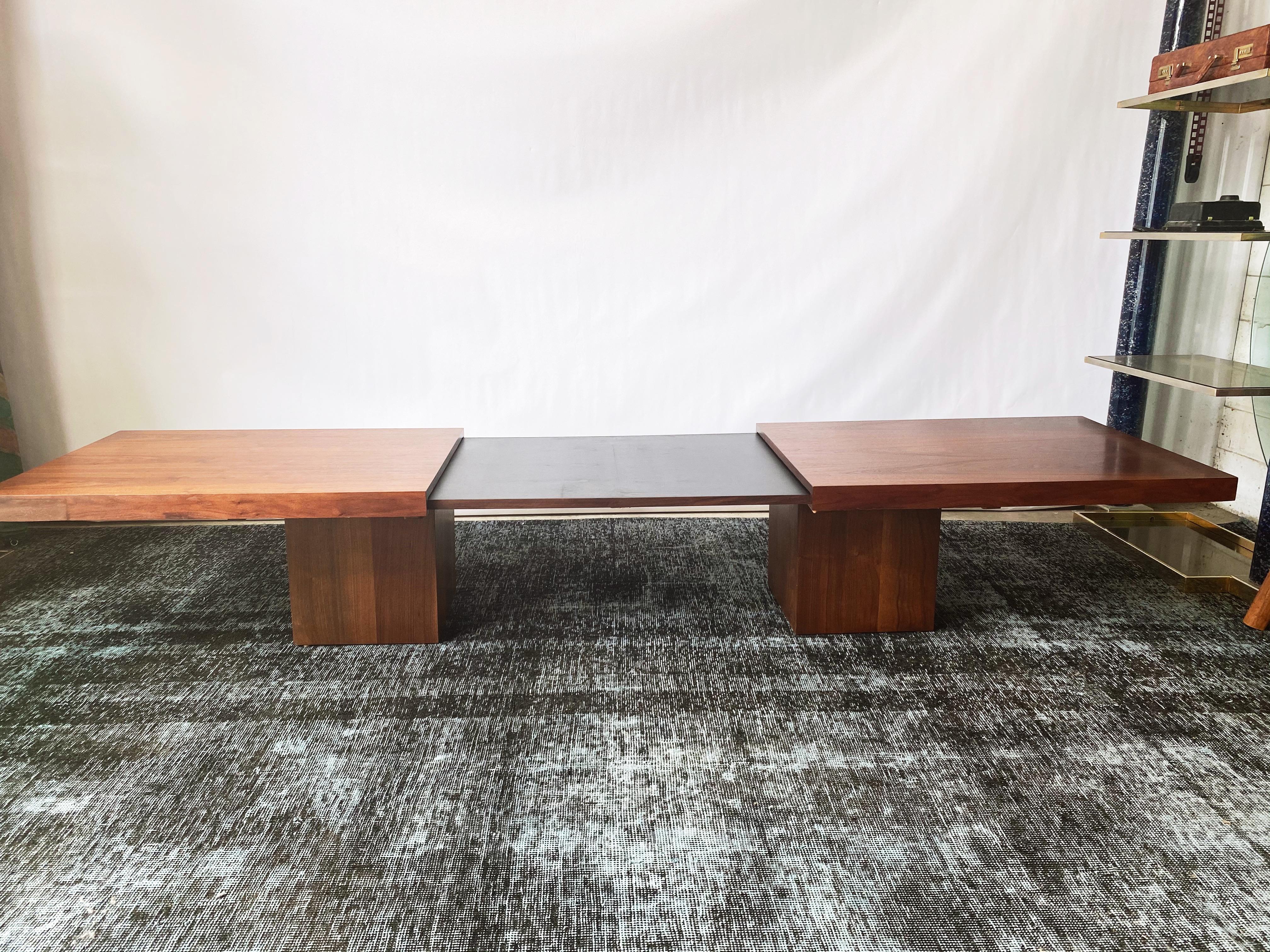 This vintage walnut expandable coffee table by John Seal for Brown Saltman is in overall excellent condition. This coffee table draws apart to reveal a black laminate interior, a perfect surface for beverages and heavy use. The minimal design