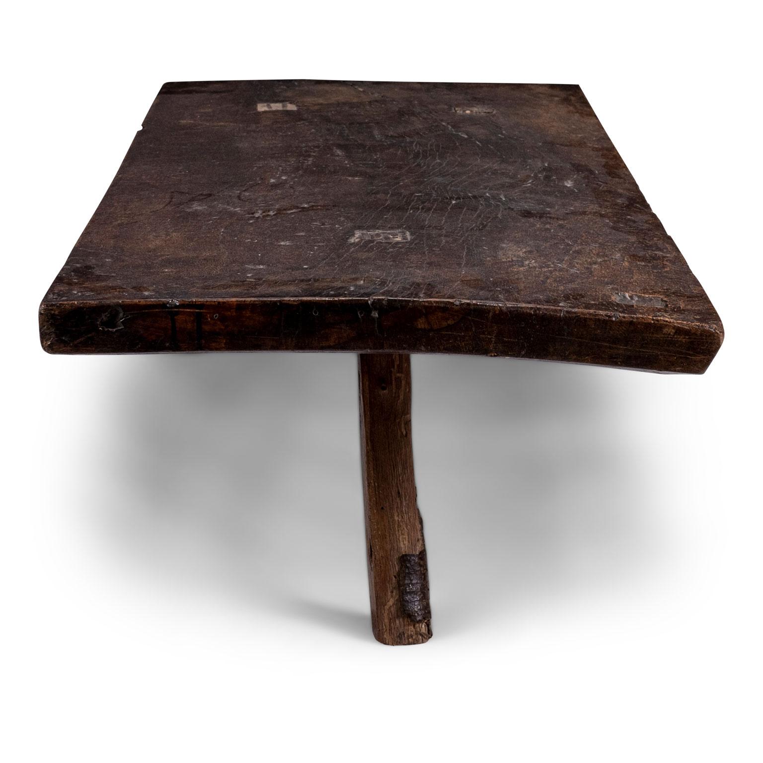 Vintage walnut coffee table, made from a thick single slab of wood (circa 19th century), supported by three simple square-shape legs. Pegged construction.